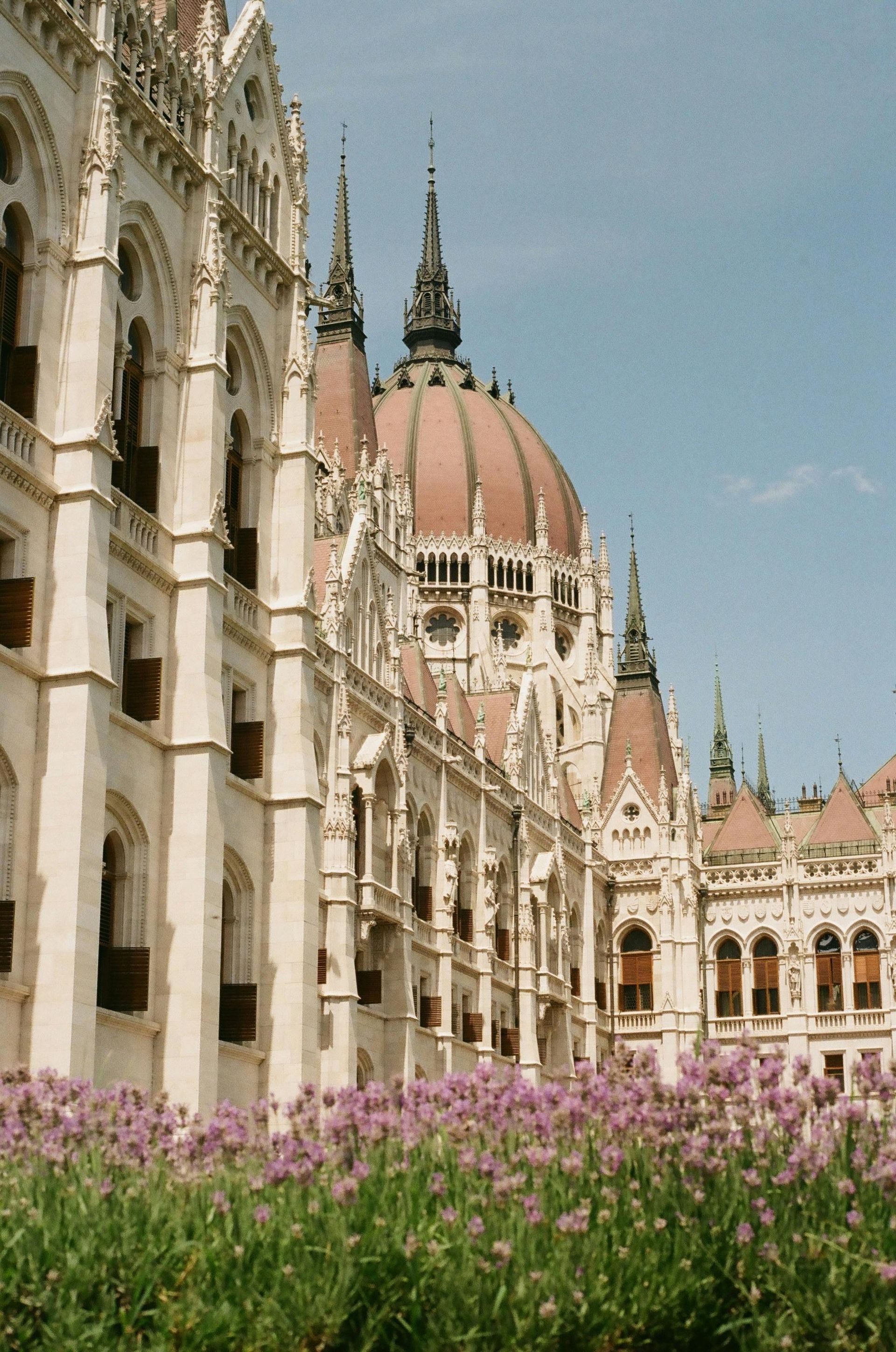 The Hungarian Parliament Building with a dome and flowers in front of it in Budapest, Hungary.