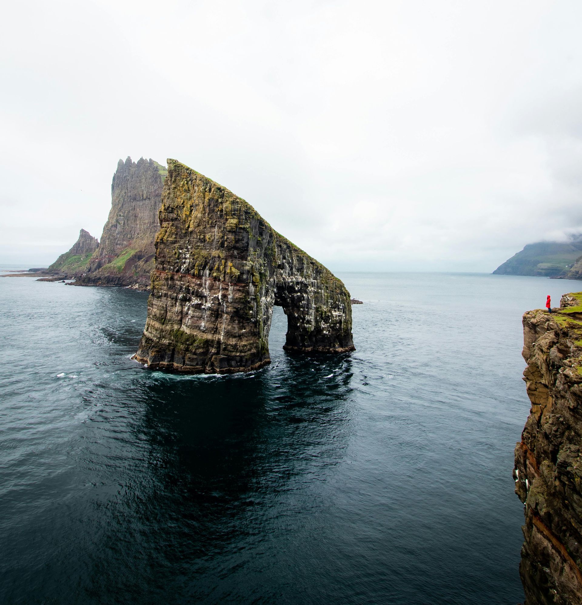 A large rock formation in the middle of a body of water on the Faroe Islands.