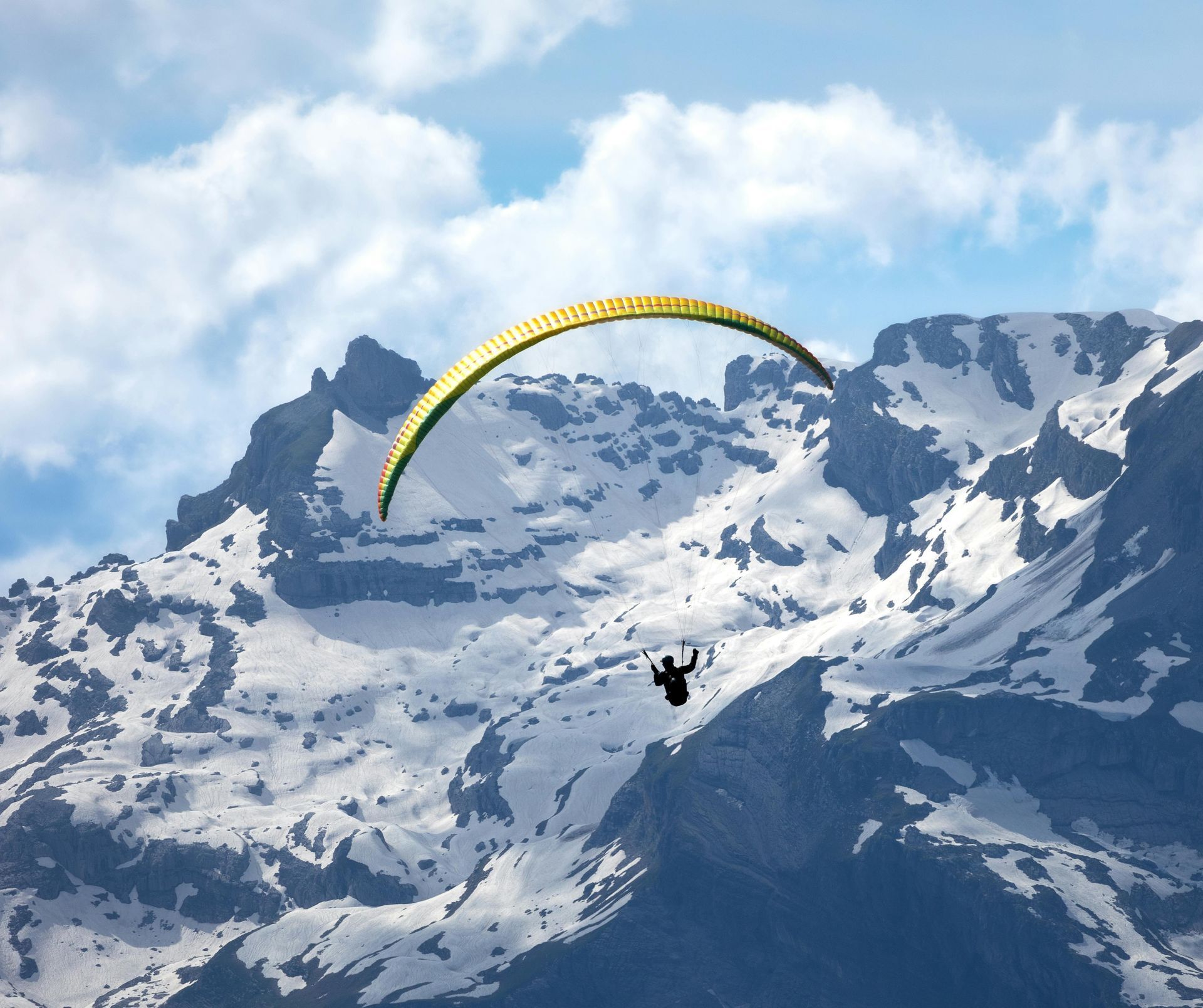 A person is parasailing over a snowy mountain in Chamonix, France.