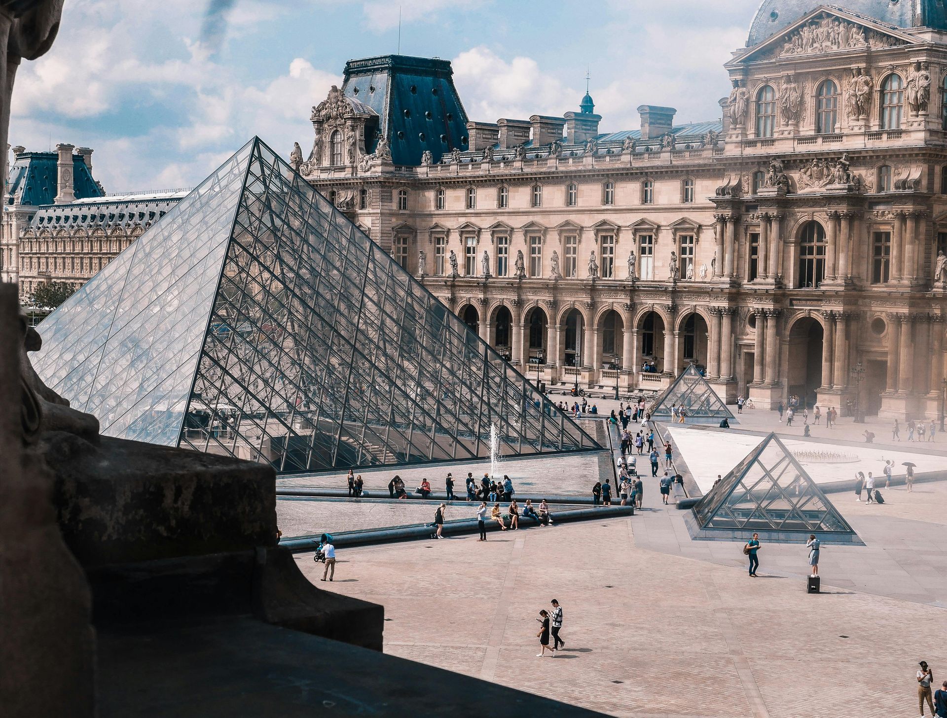 A large building with the Louvre pyramid in front of it in Paris, France.