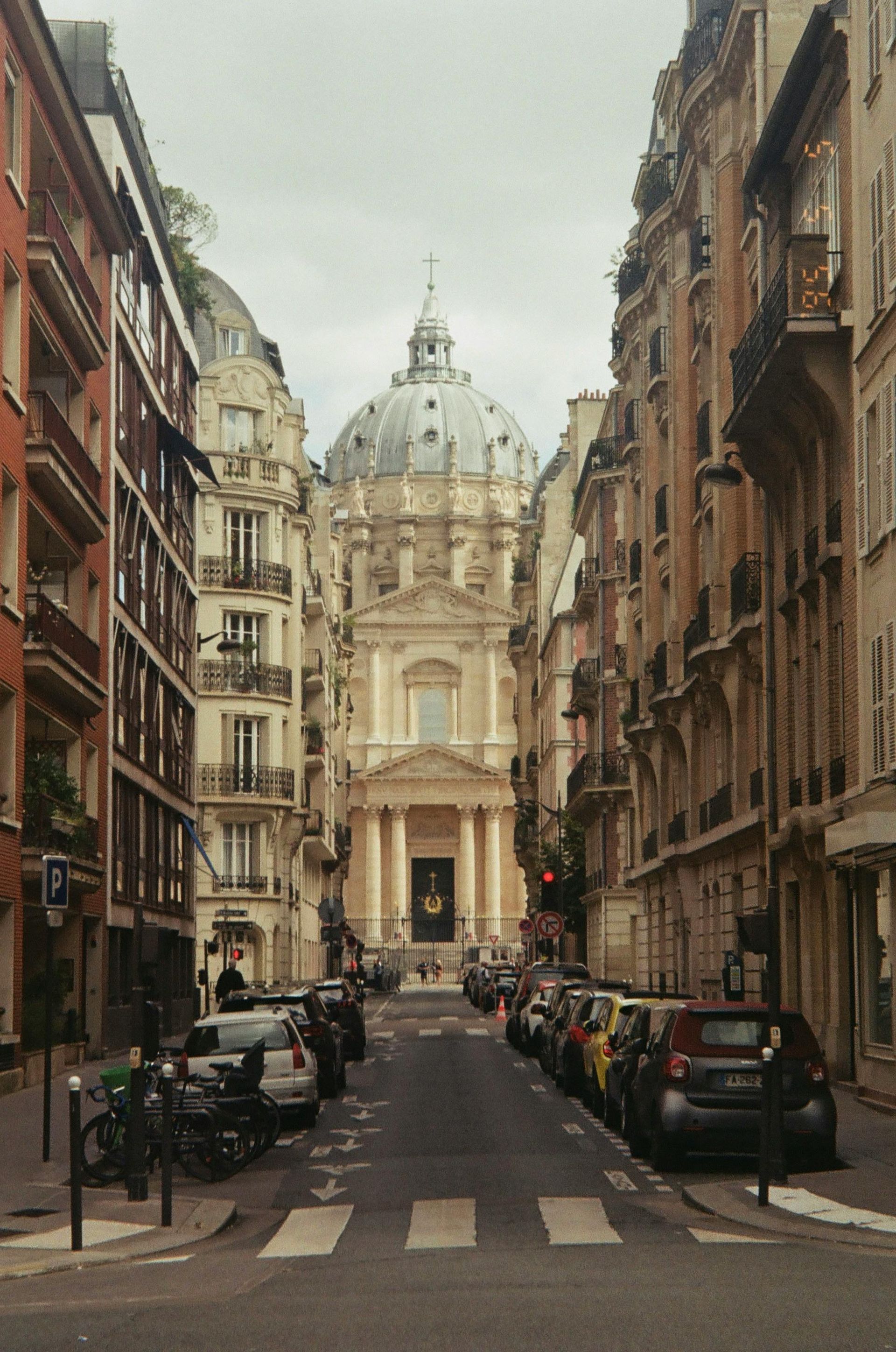 A city street in Champagne, France with a dome shaped building in the background.