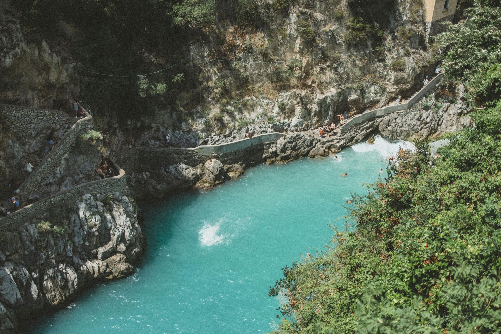 A large body of water surrounded by rocks and trees in the Amalfi Coast, Italy.