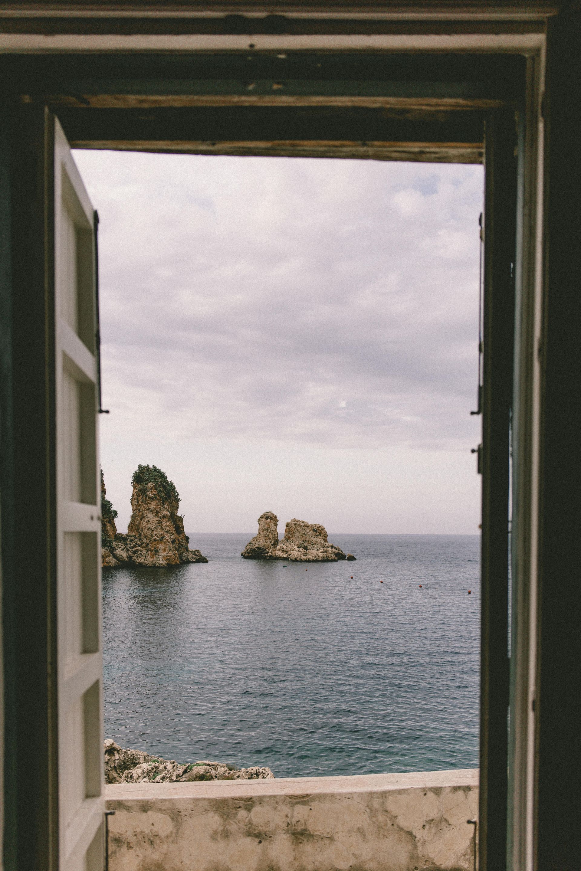 A view of the ocean through an open door in Sicily, Italy.