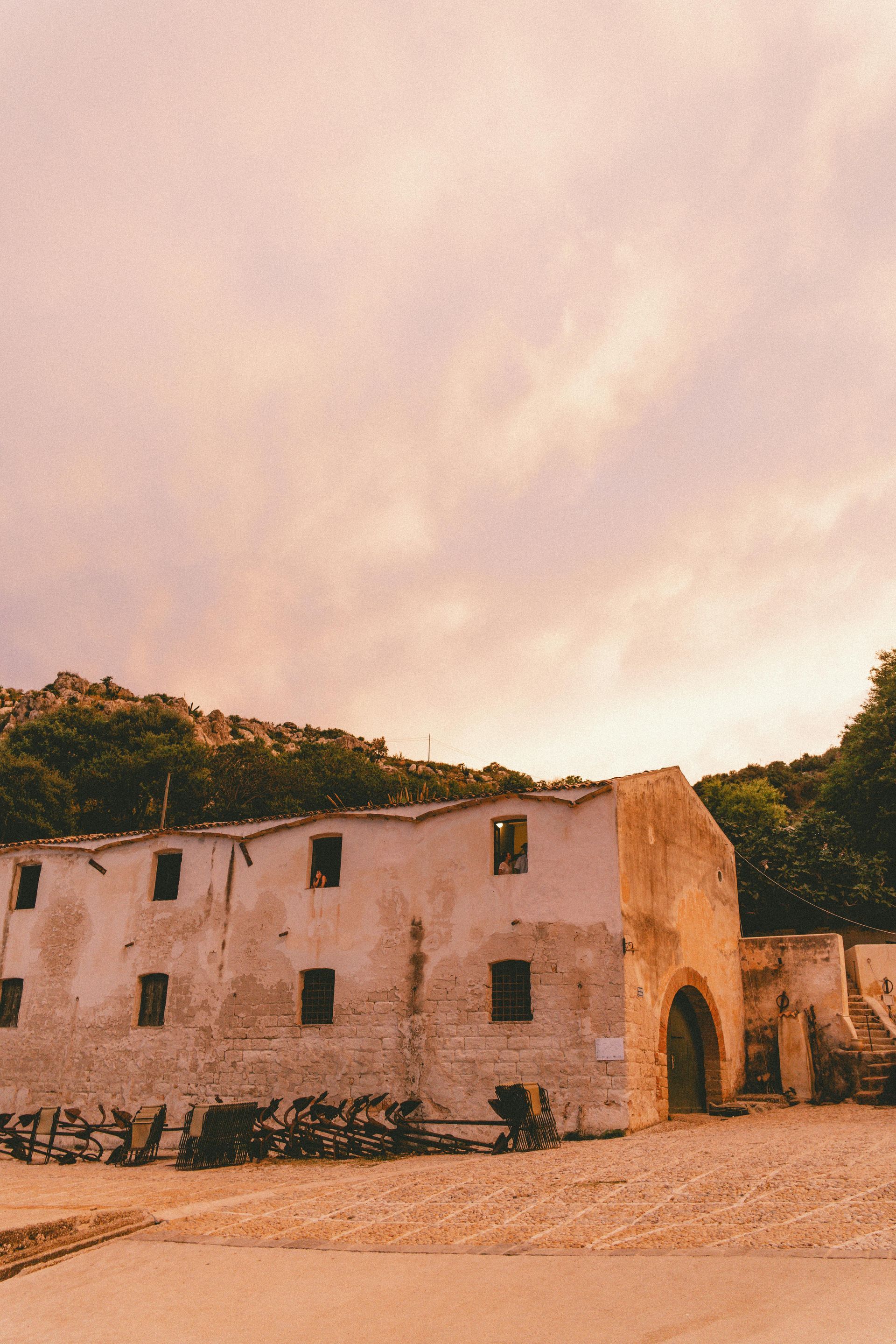 An old building with a pink sky in the background in Sicily, Italy.