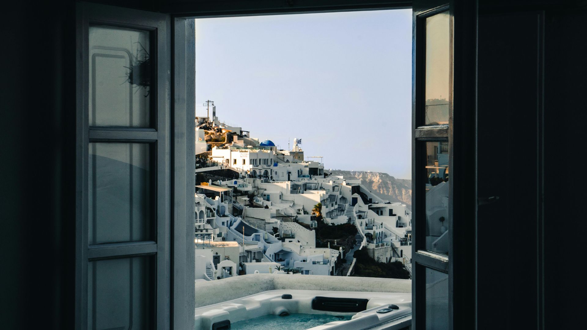 A view of a hot tub from an open window in Santorini, Greece.