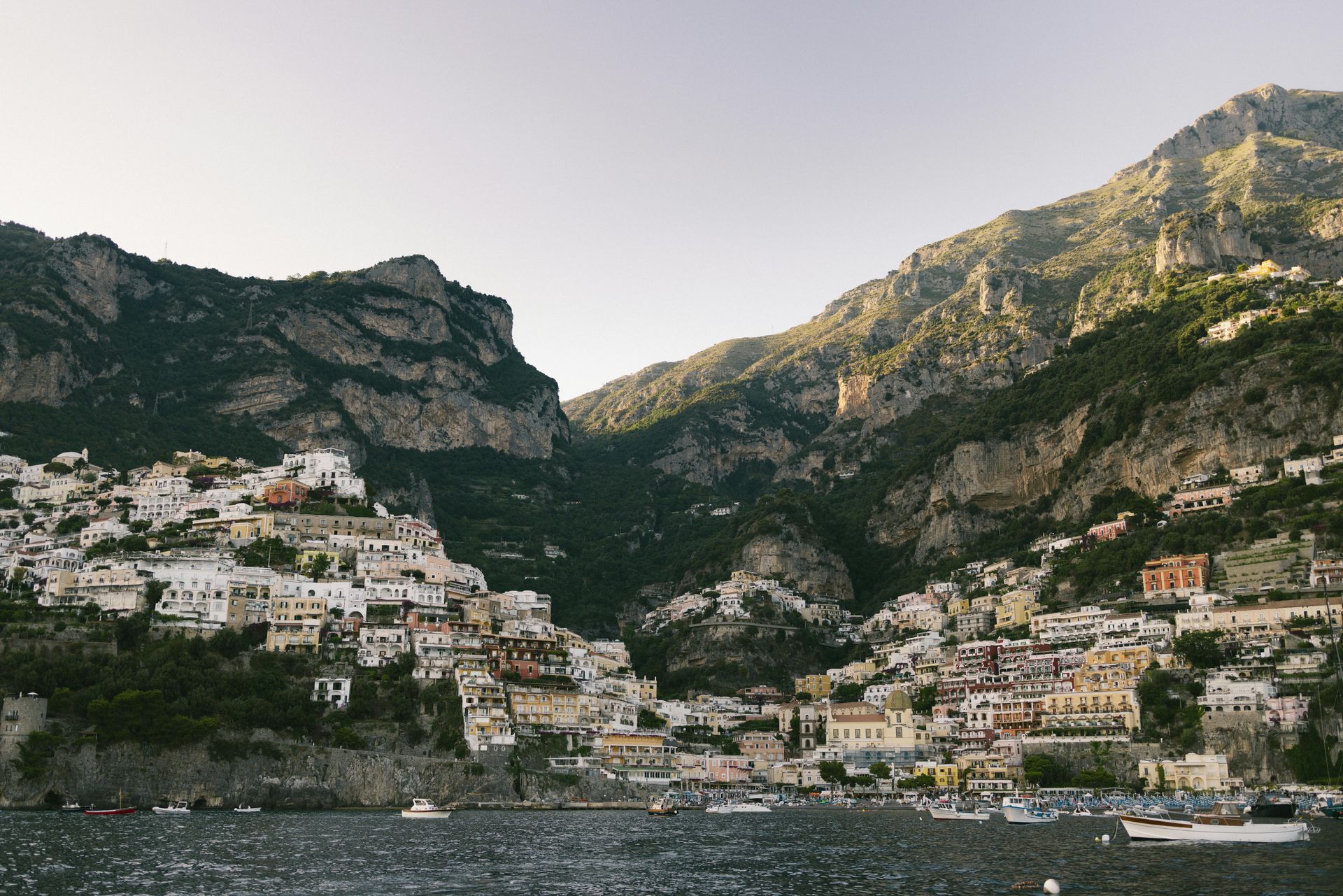 The Amalfi Coast is surrounded by mountains and a body of water in Italy.