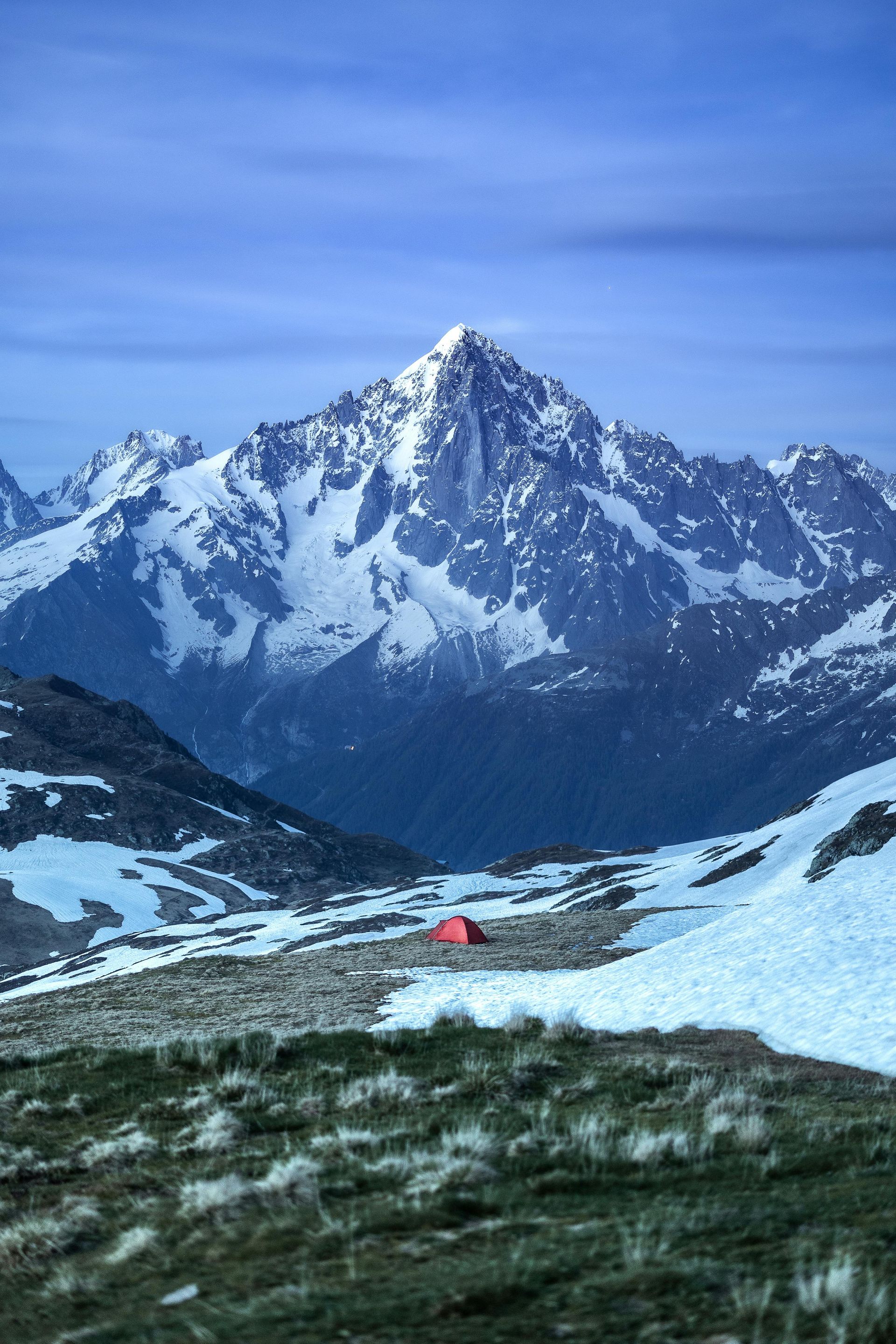 A red tent is sitting on top of a snowy mountain in Chamonix, France.