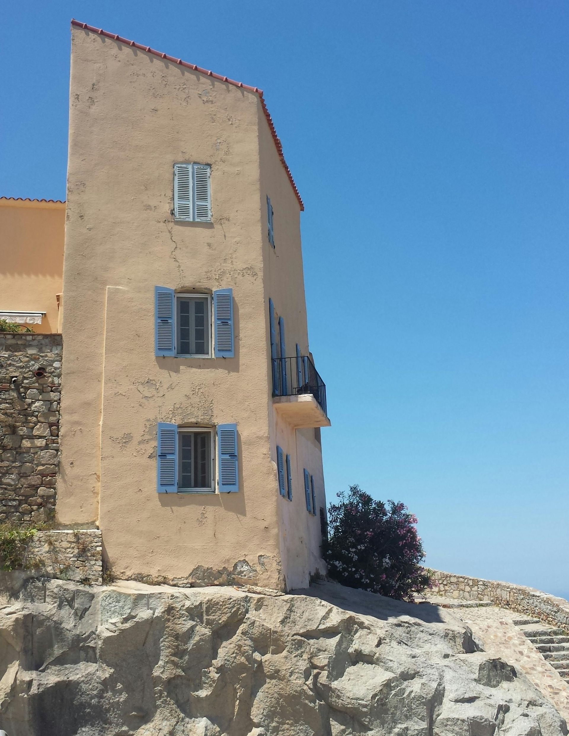 A very tall building with blue shutters on the windows in Champagne, France.