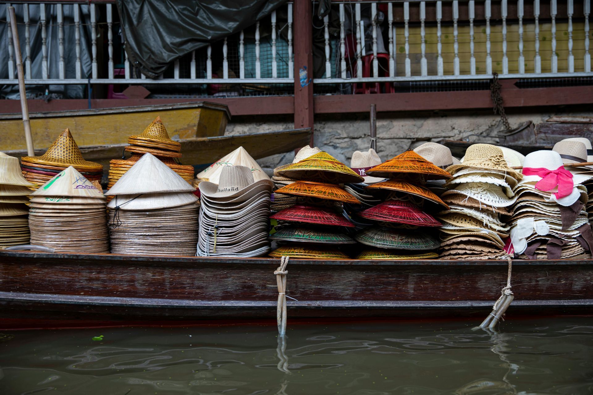 A bunch of hats are stacked on top of each other on a boat in Laos.