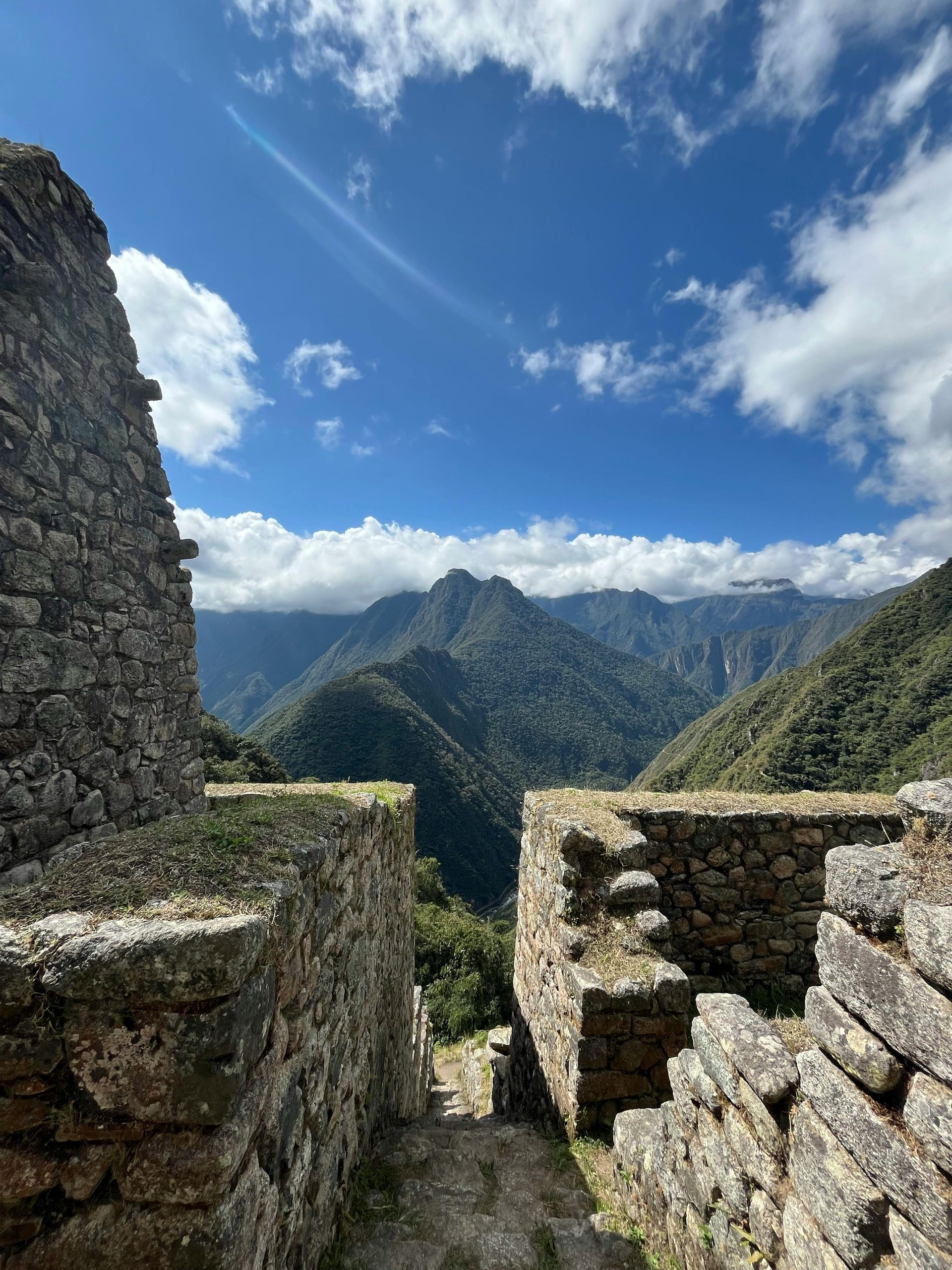 A stone wall with a view of mountains in the background in Peru.