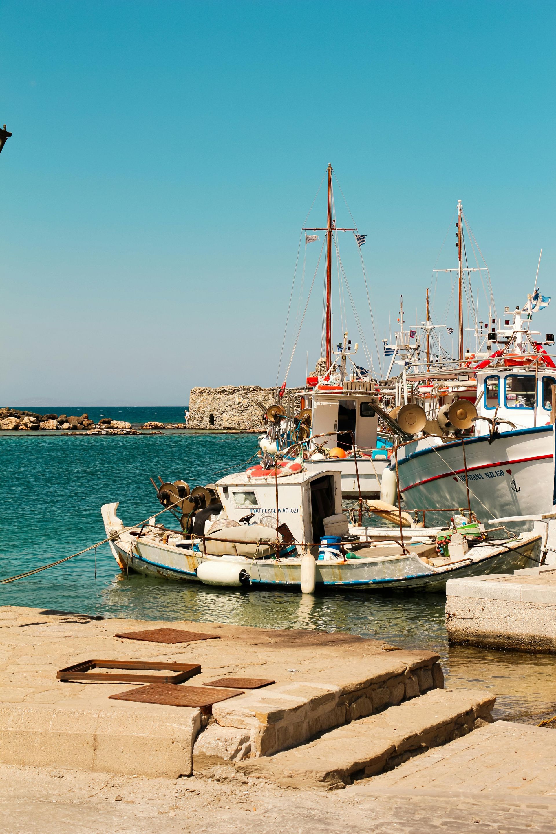 A group of boats are docked in a harbor in Paros, Greece.