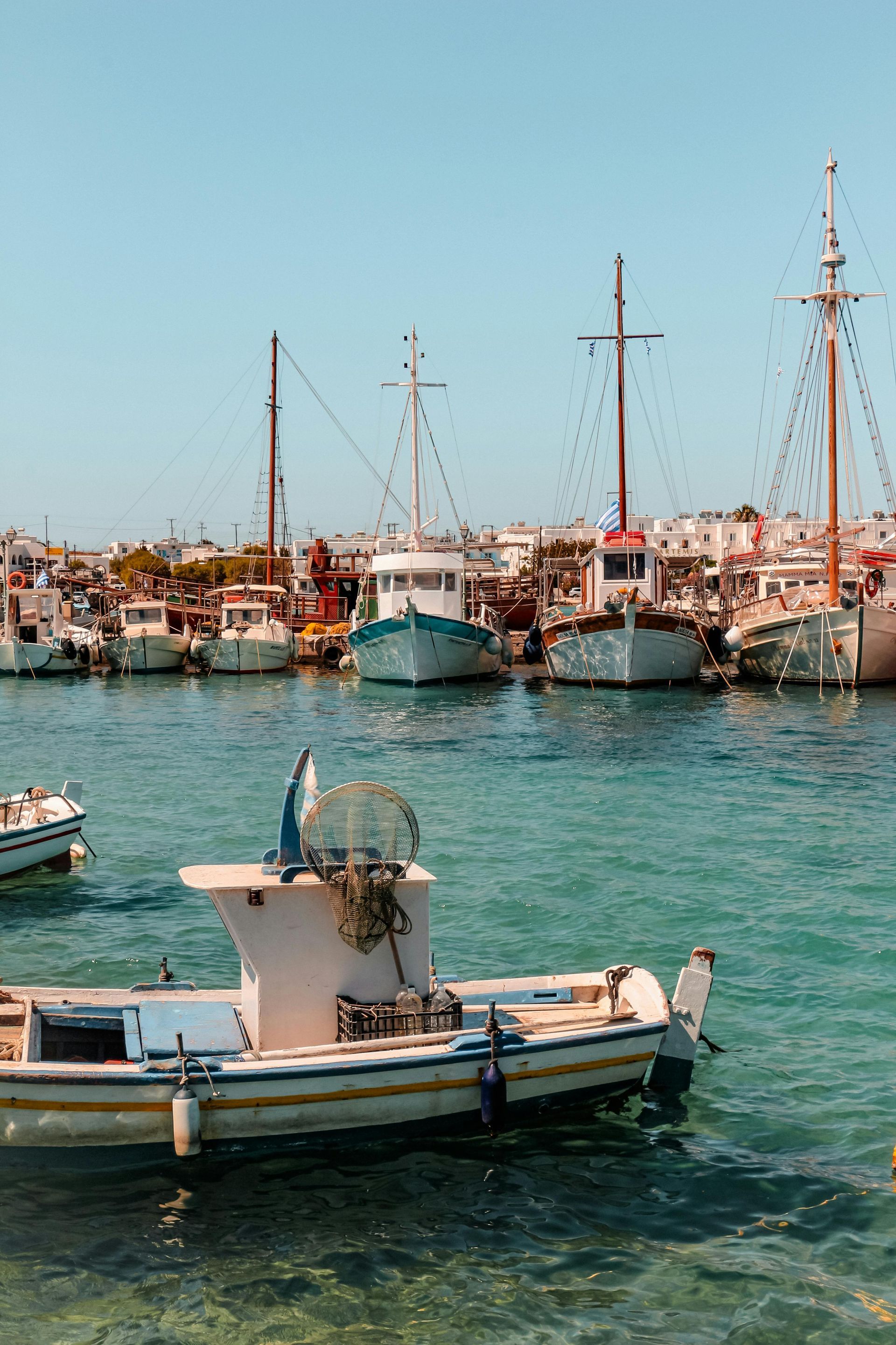 A group of boats are docked in a harbor in Paros, Greece.