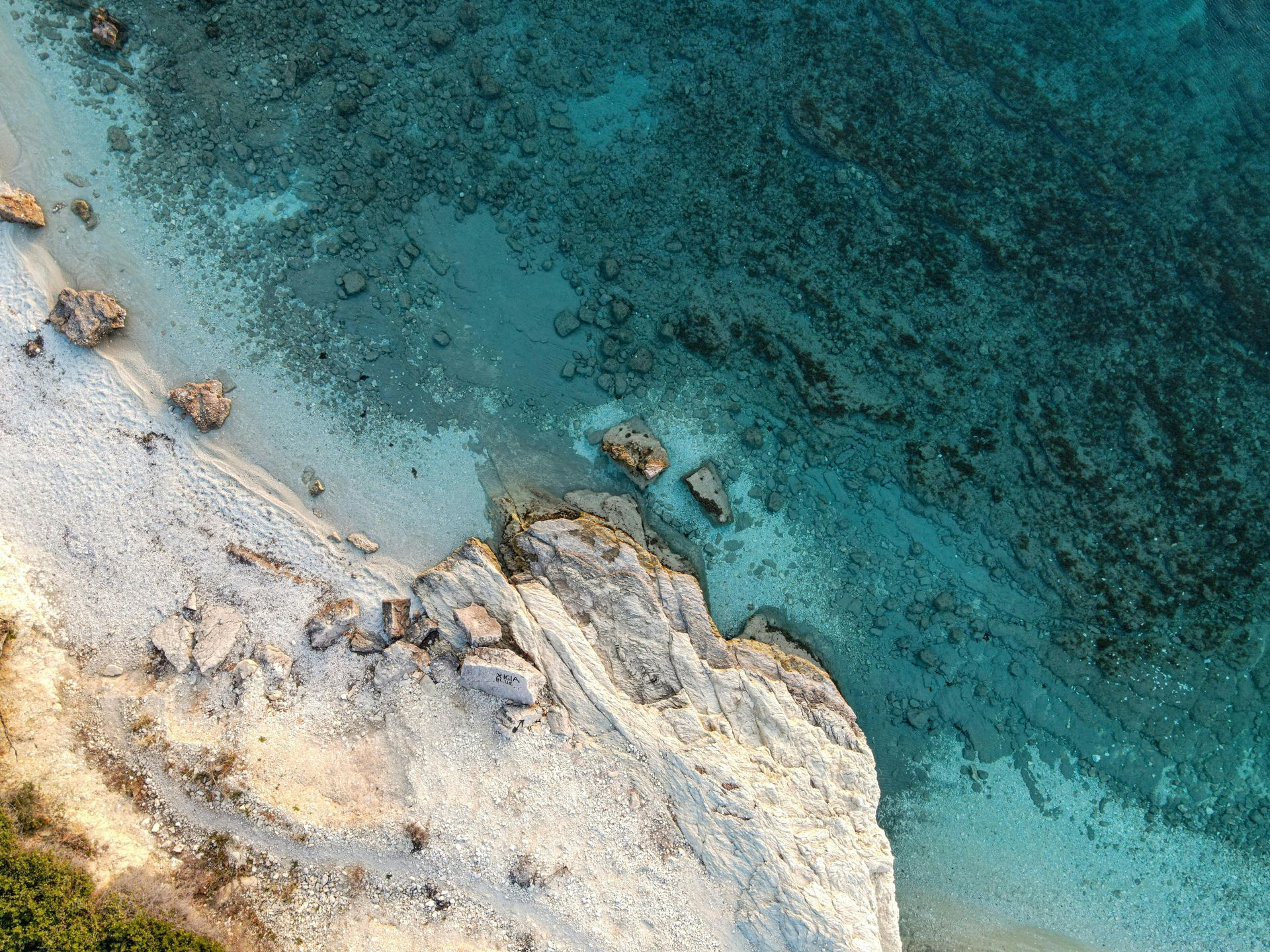 An aerial view of a rocky shoreline next to a body of water in the Caribbean.