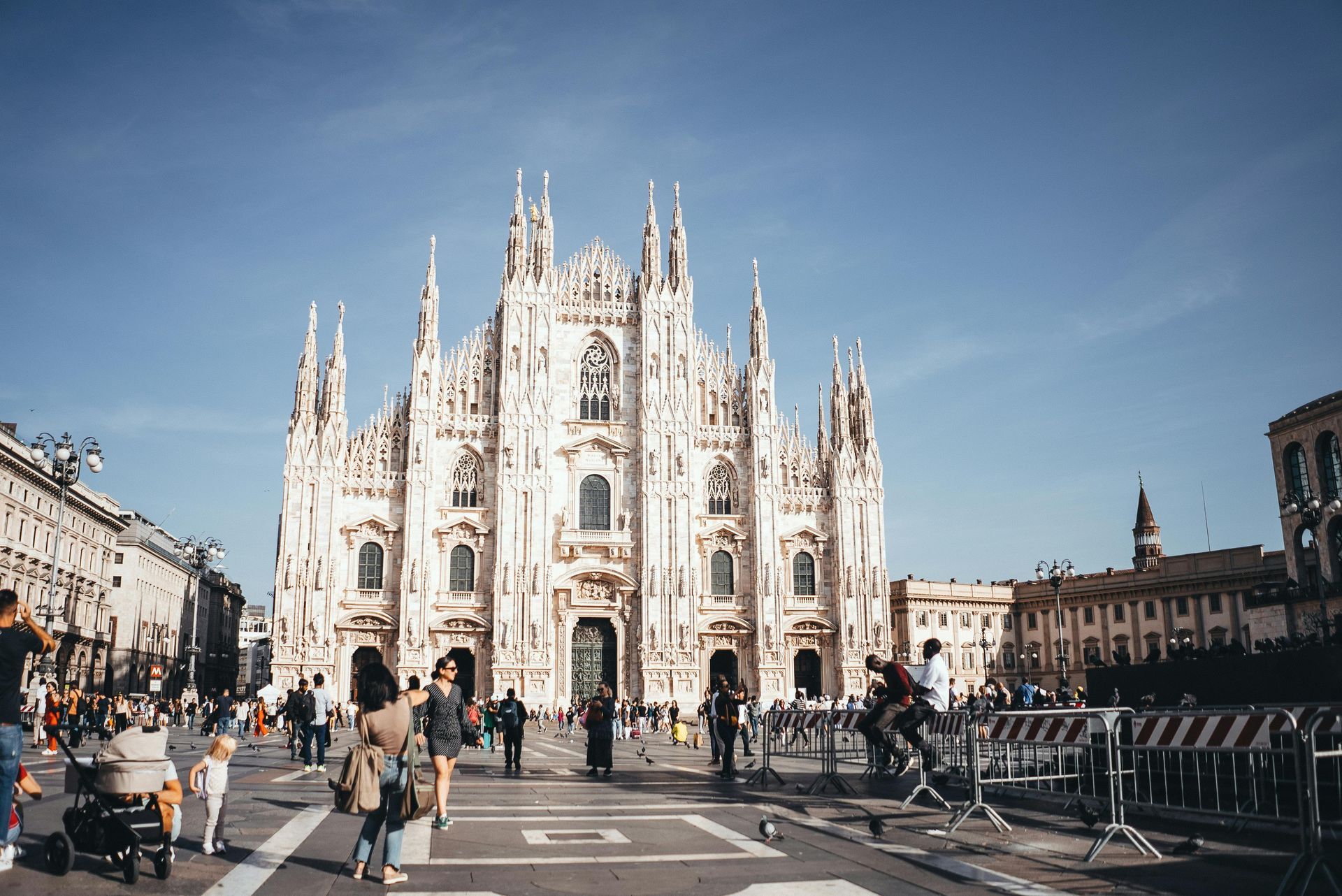 A group of people are walking in front of a Duomo di Milano in Milan, Italy.