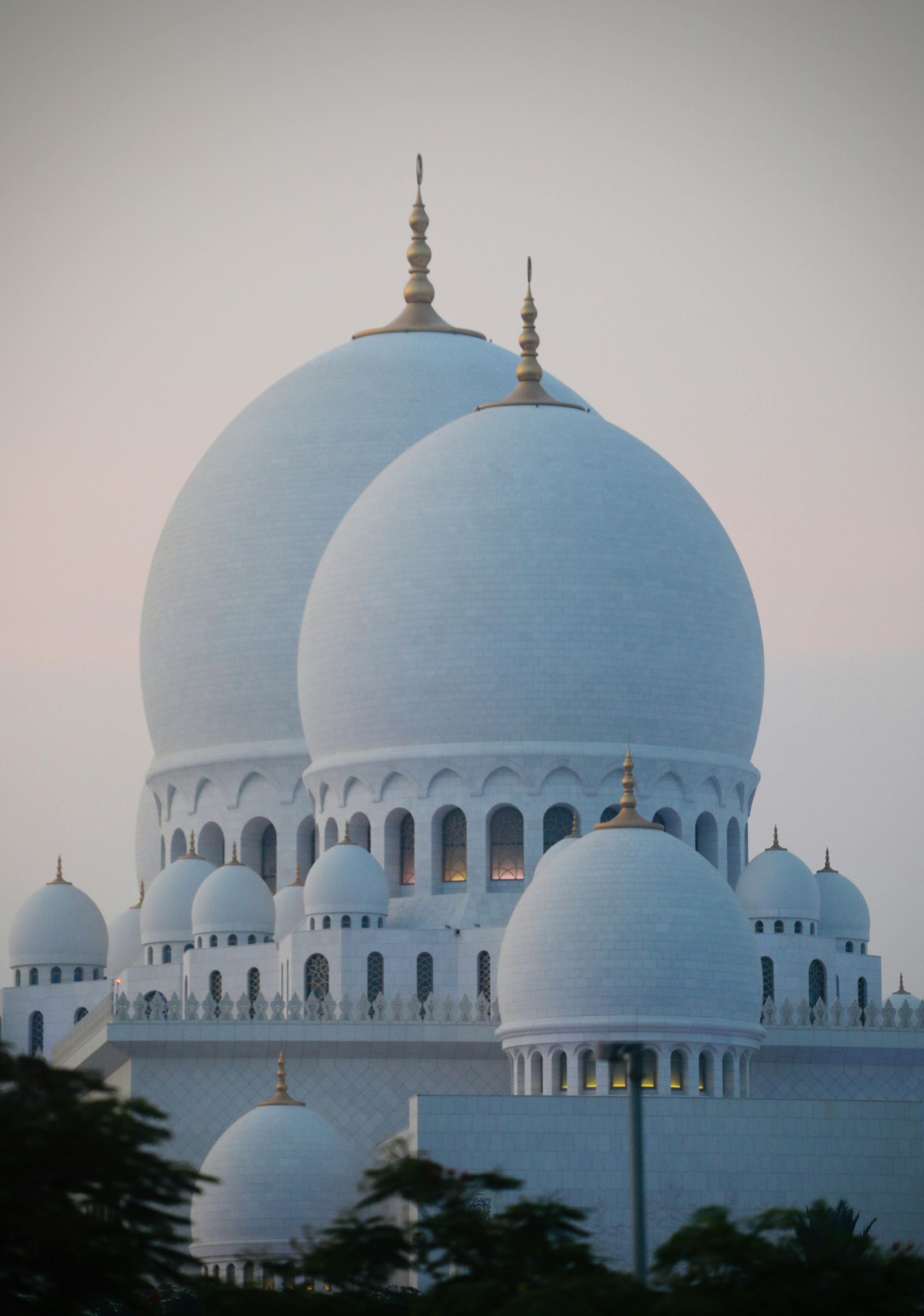 A large white dome shaped building with trees in the foreground in India.