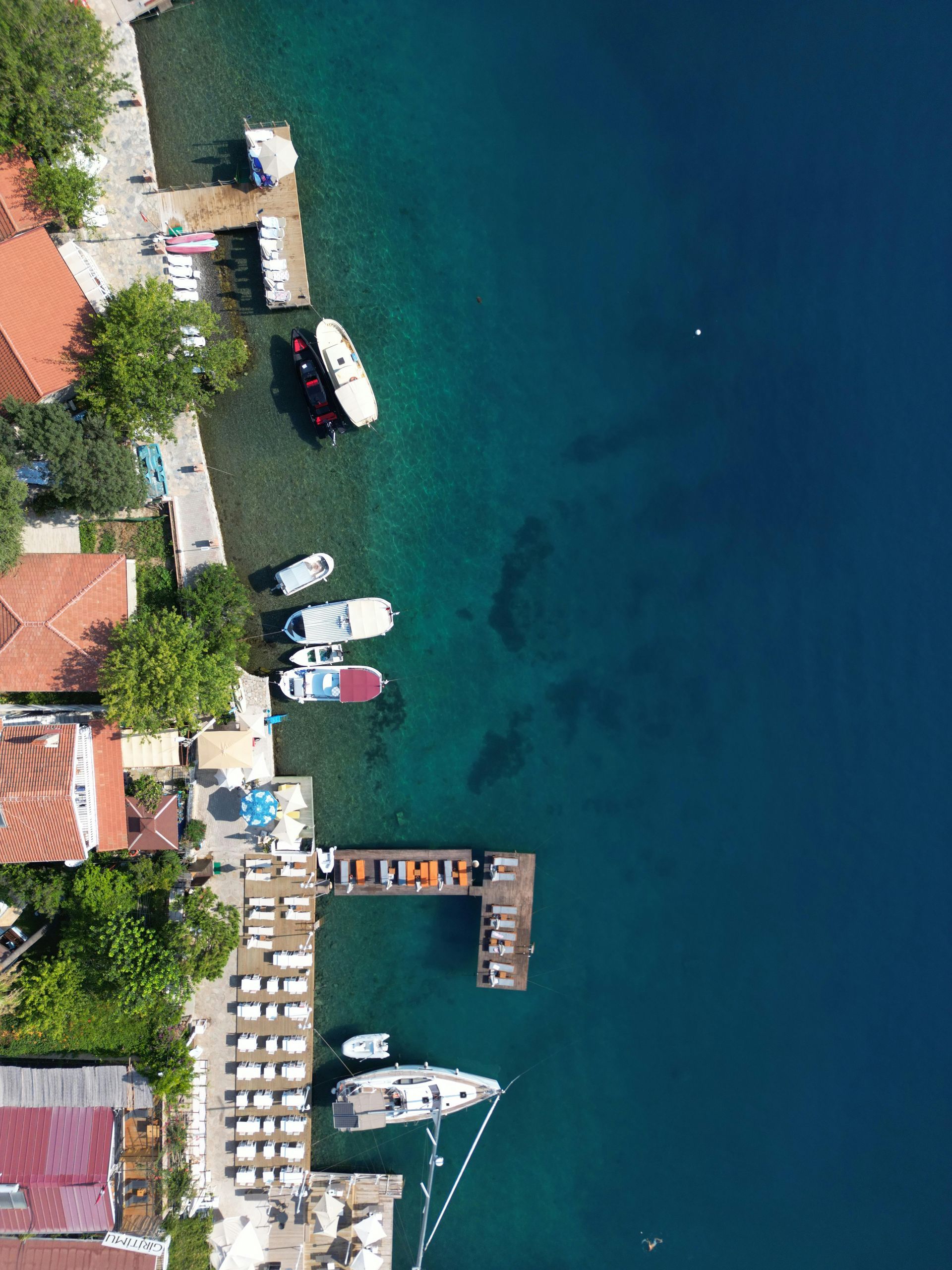 An aerial view of a dock with boats docked in the Mediterranean ocean.