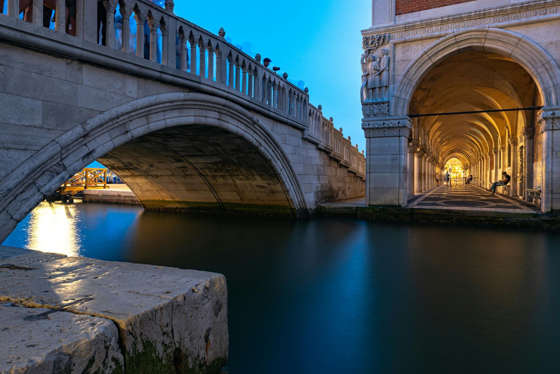 A bridge over a canal with a building in the background in Venice, Italy.