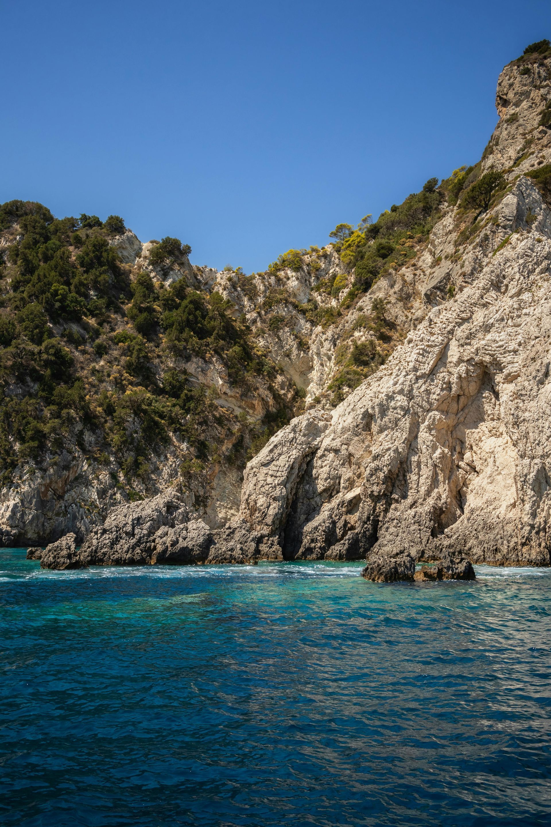 A view of a cliff overlooking the ocean from a boat in Zakynthos, Greece.