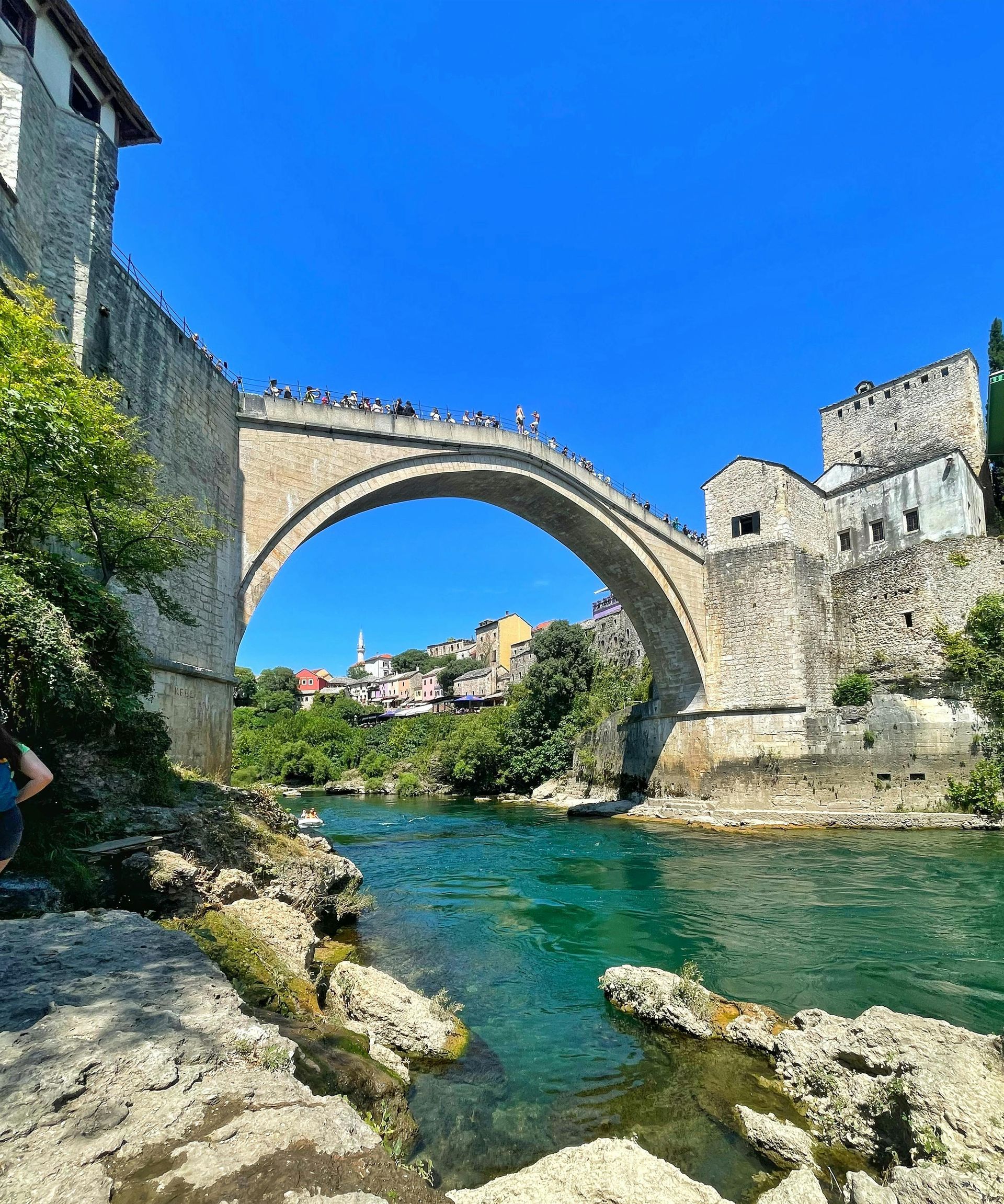 The Old Bridge Mostar over a river with a blue sky in the background in Bosnia and Herzegovina.