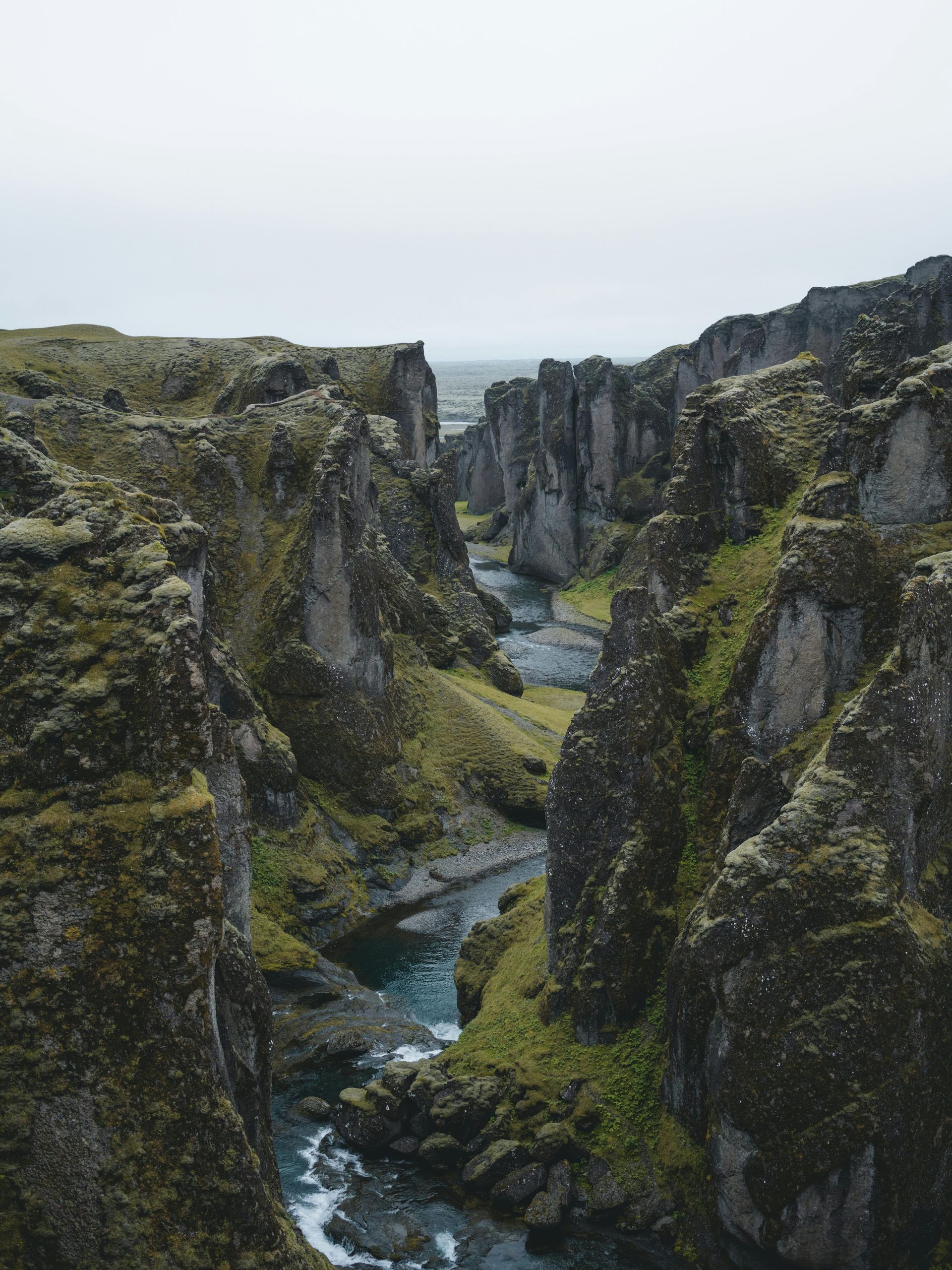 A river runs through a canyon between two mountains in Iceland.