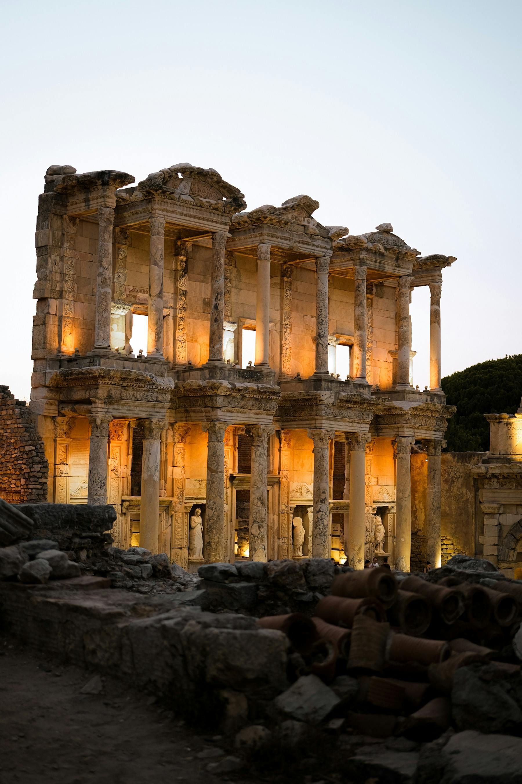 An ancient building with columns and arches is lit up at night in Athens, Greece.