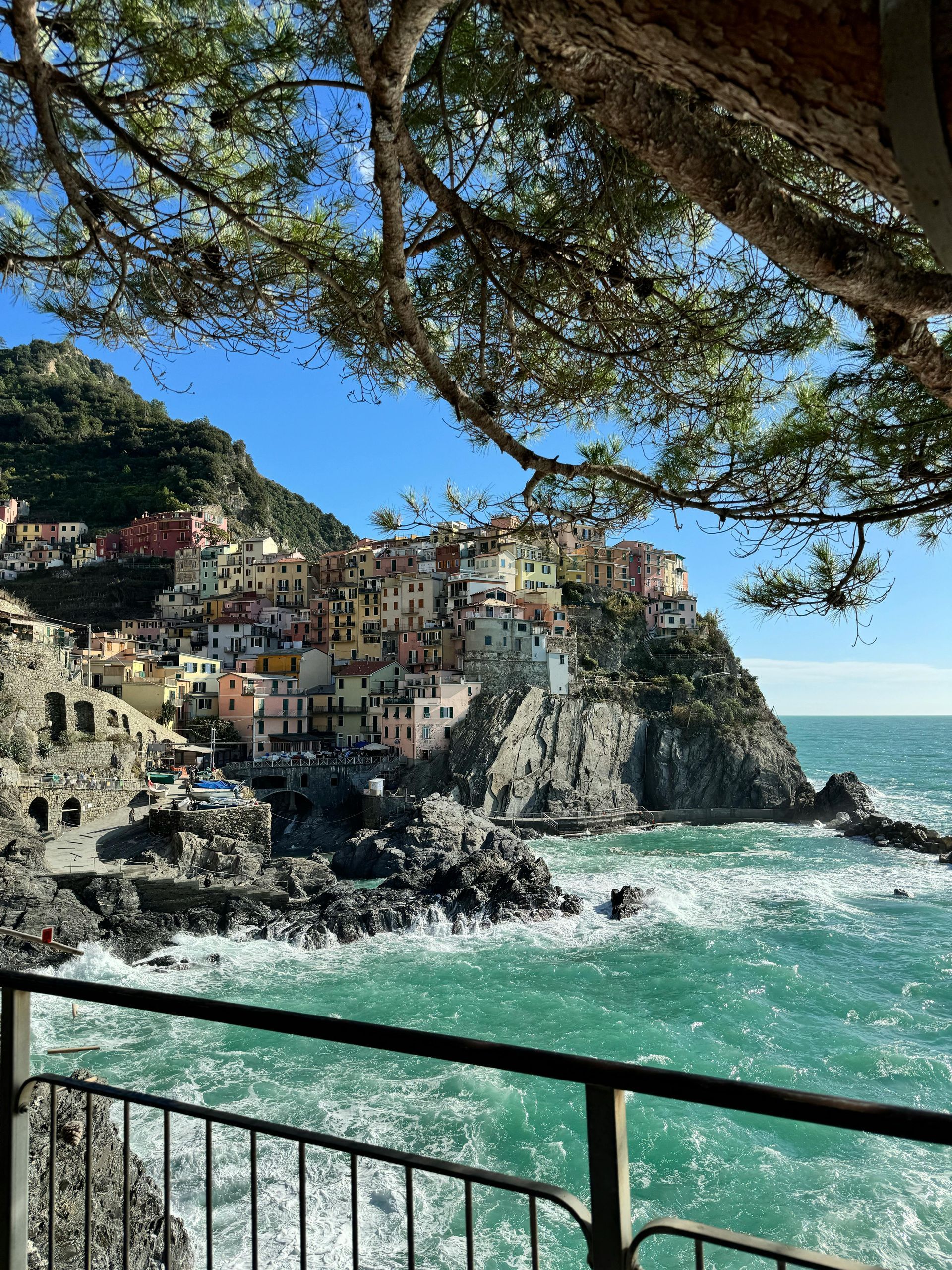 A view of Cinque Terre from a balcony overlooking the ocean in Italy.