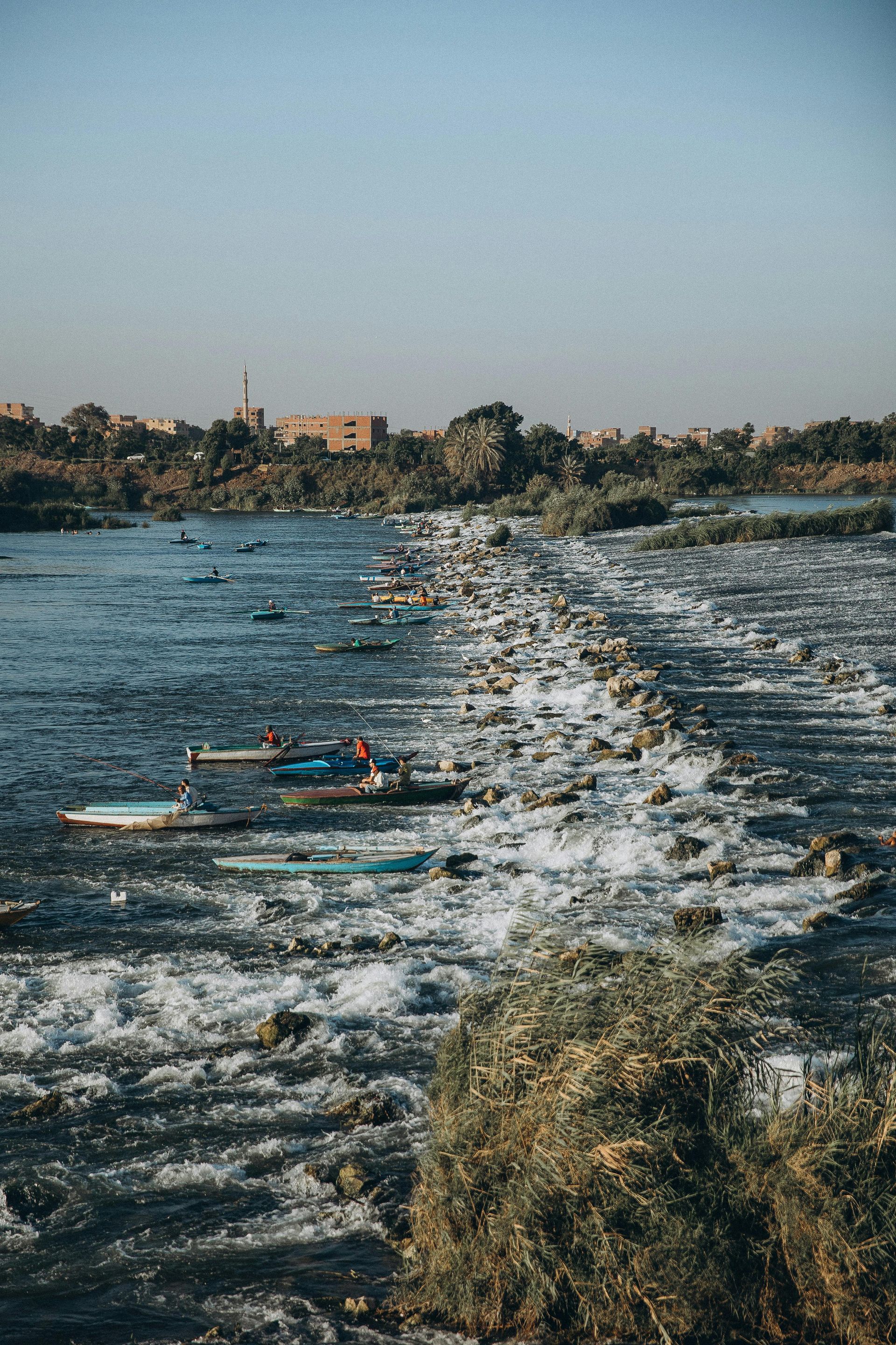 A group of boats are floating on top of a river in Egypt.