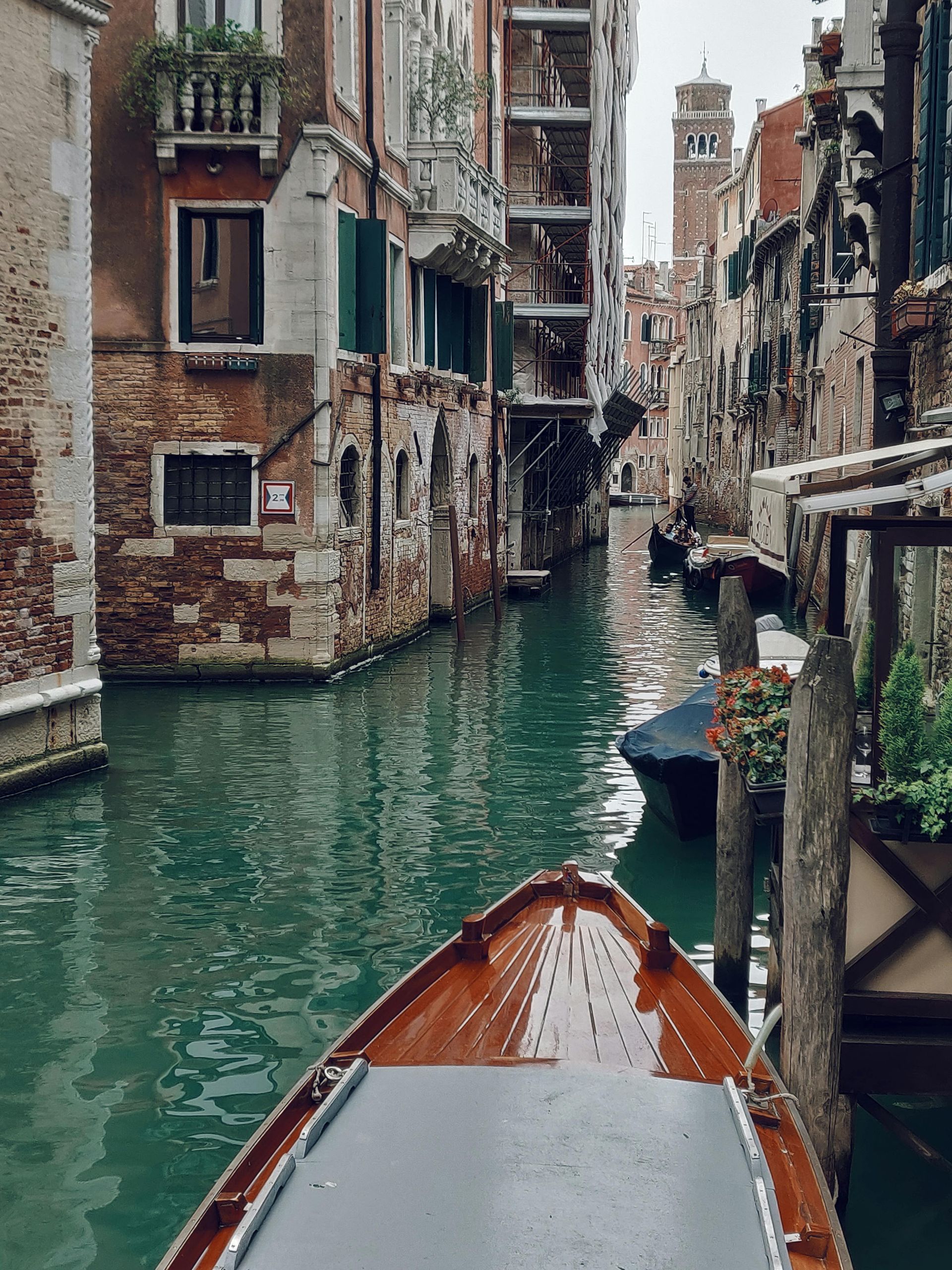 A boat is going down a canal in venice, Italy.