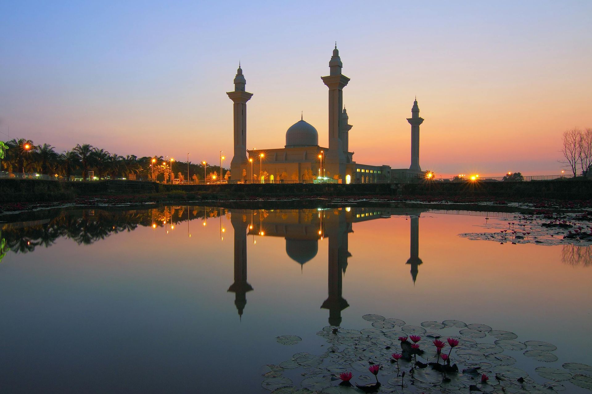 A mosque is reflected in the water at sunset in Malaysia.