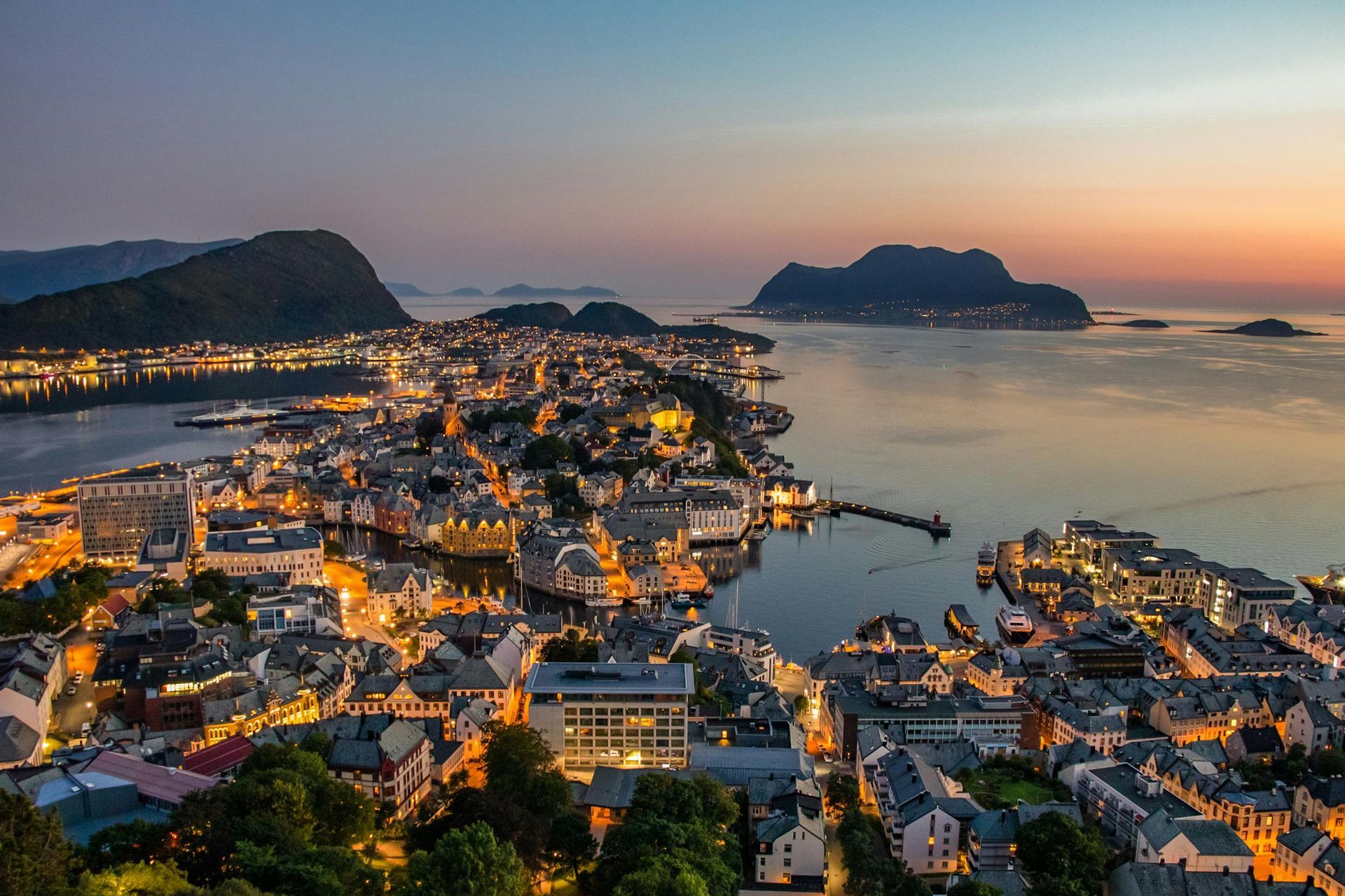 An aerial view of a city surrounded by water at night on the Norwegian Coast.