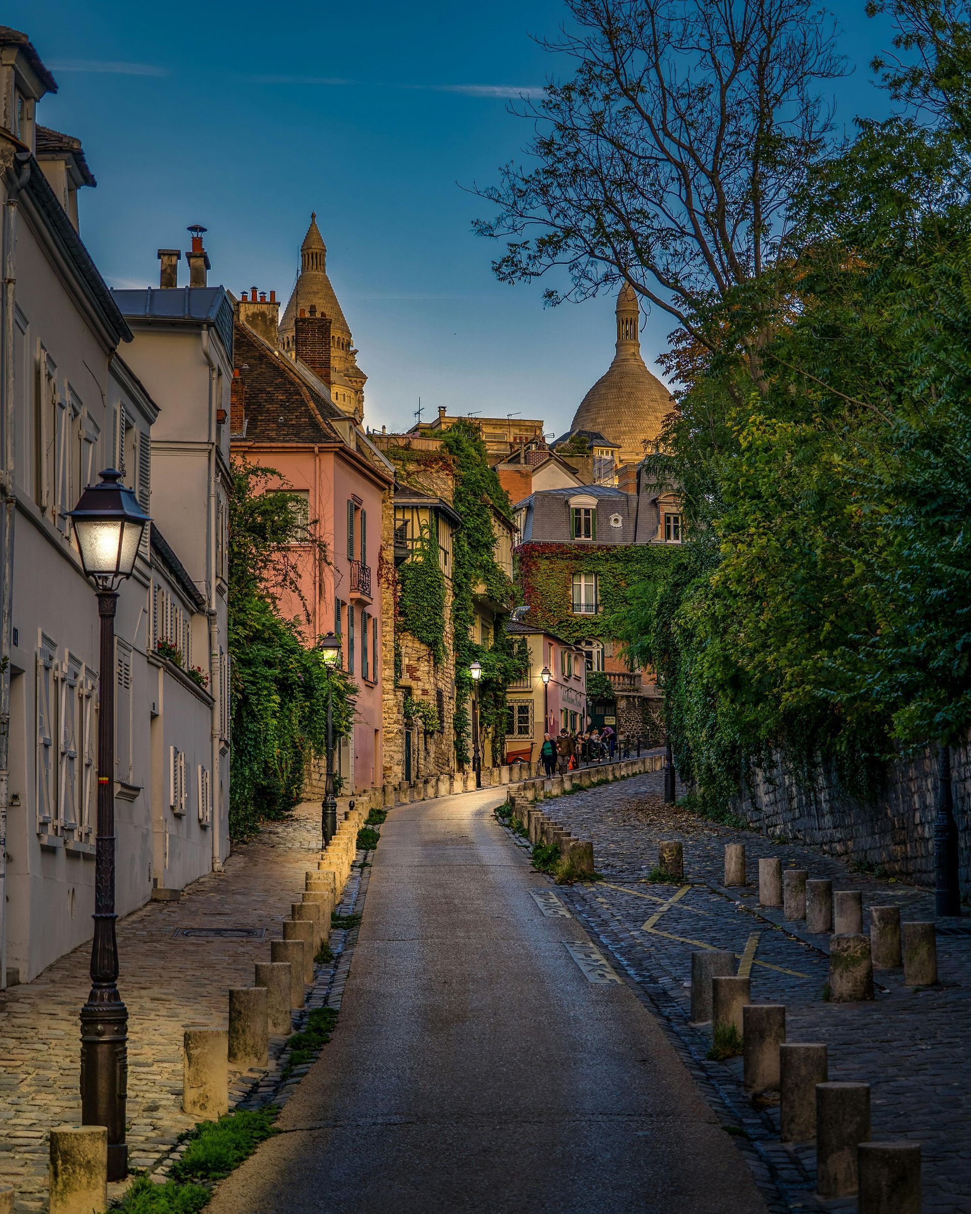 A cobblestone street in paris with a church in the background