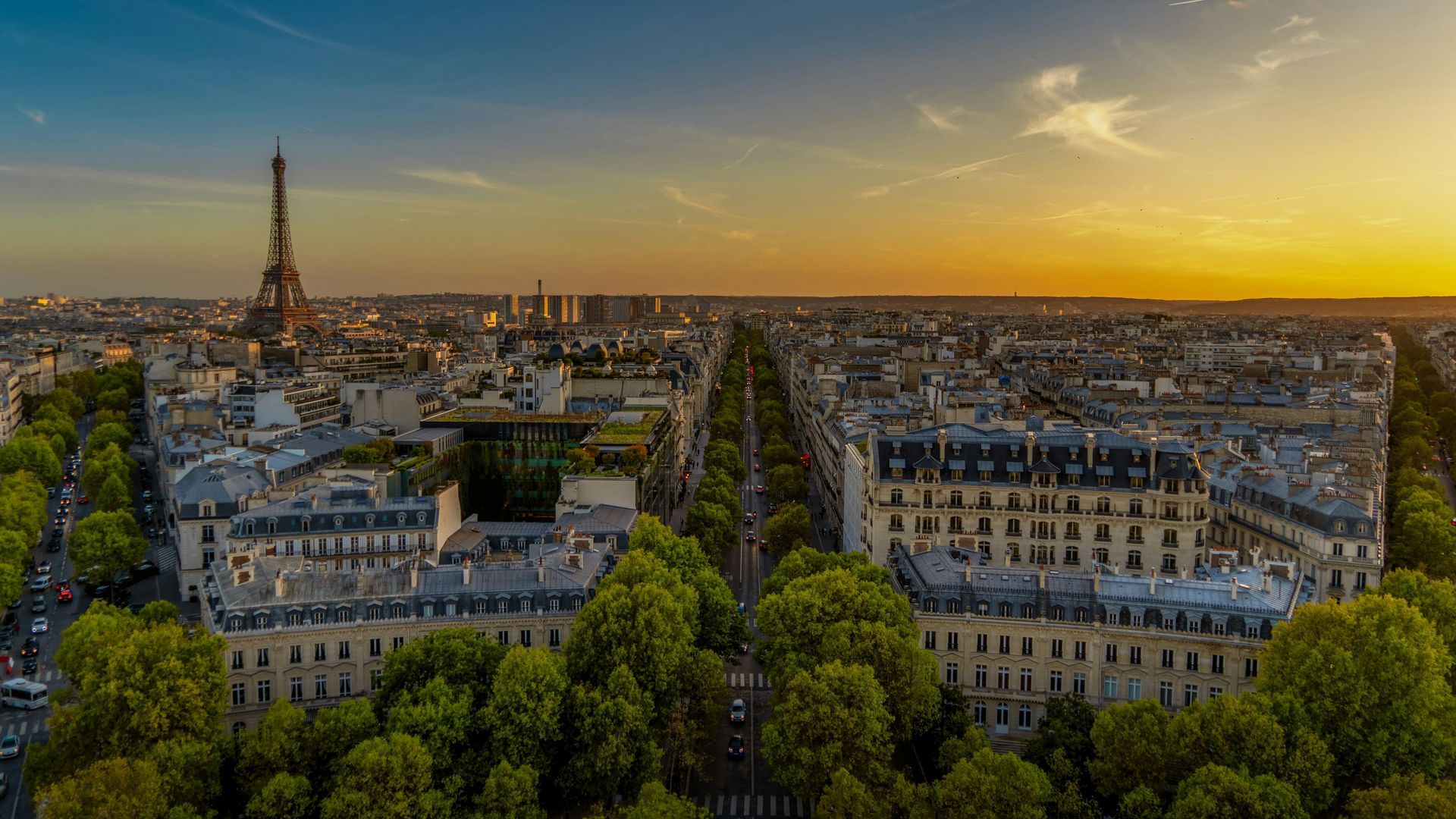 An aerial view of paris at sunset with the eiffel tower in the background.