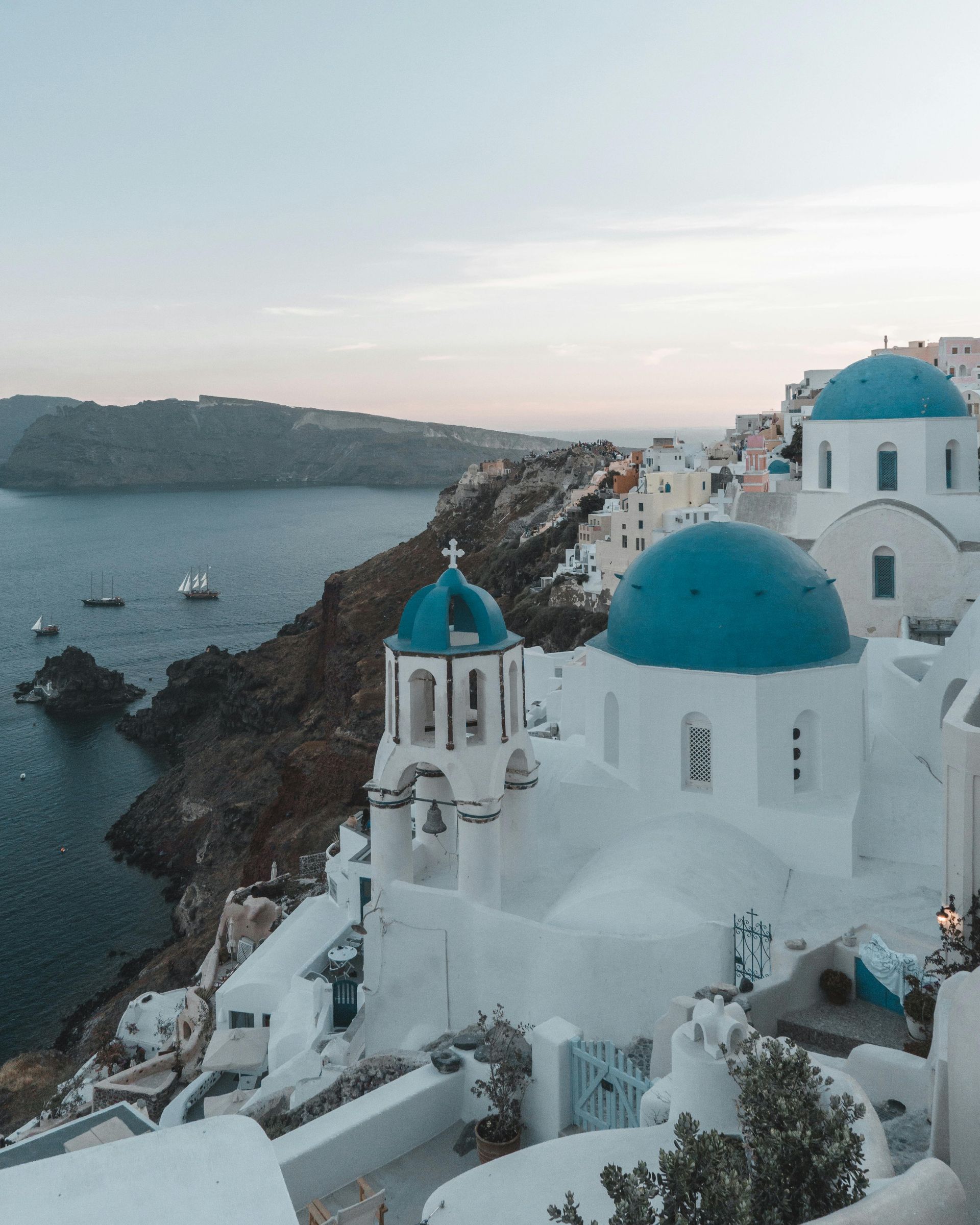 A white building with a blue dome on top of it in Santorini, Greece.