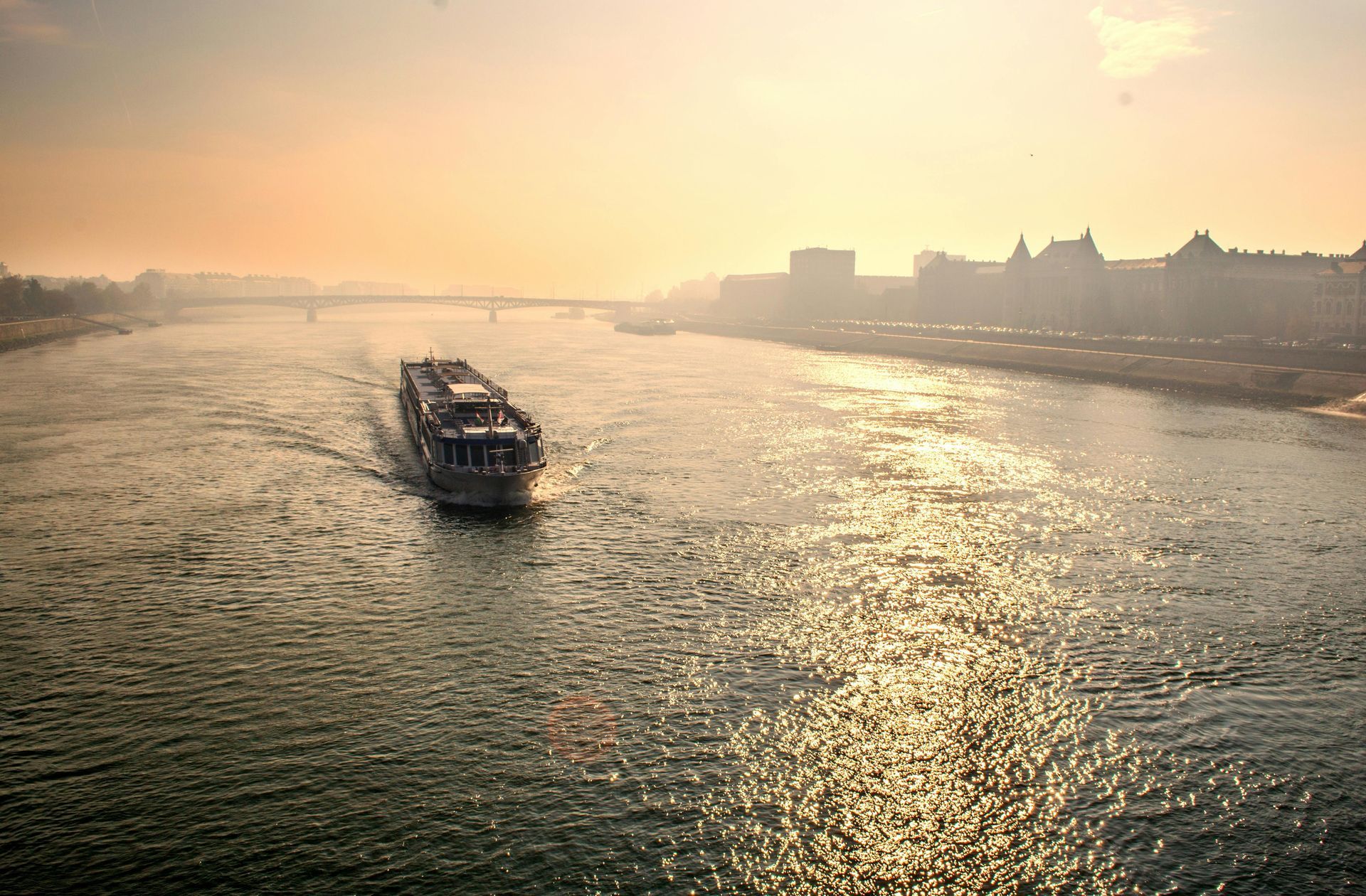 A boat is floating on The Danube River at sunset.