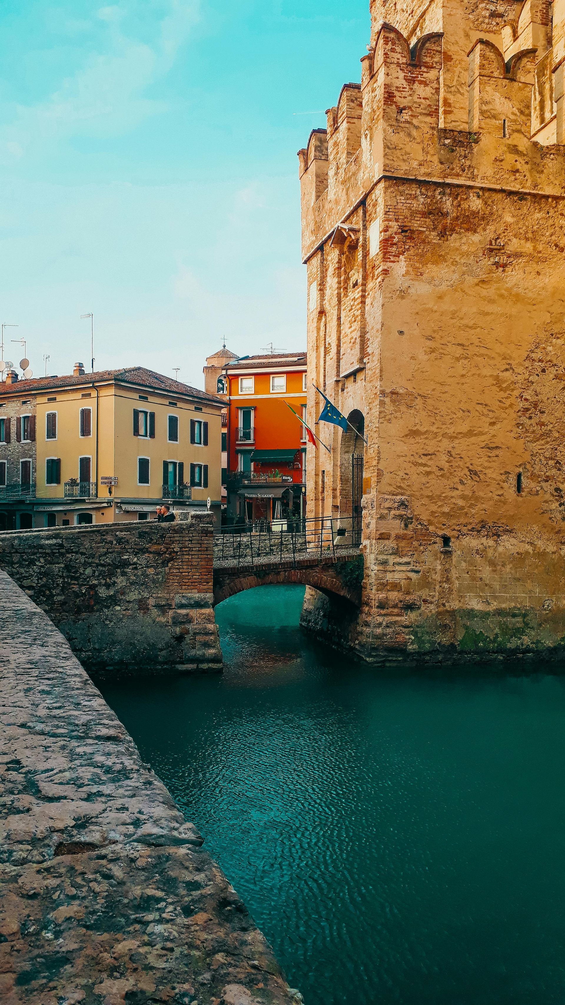 There is a bridge over a body of water between two buildings in Switzerland.