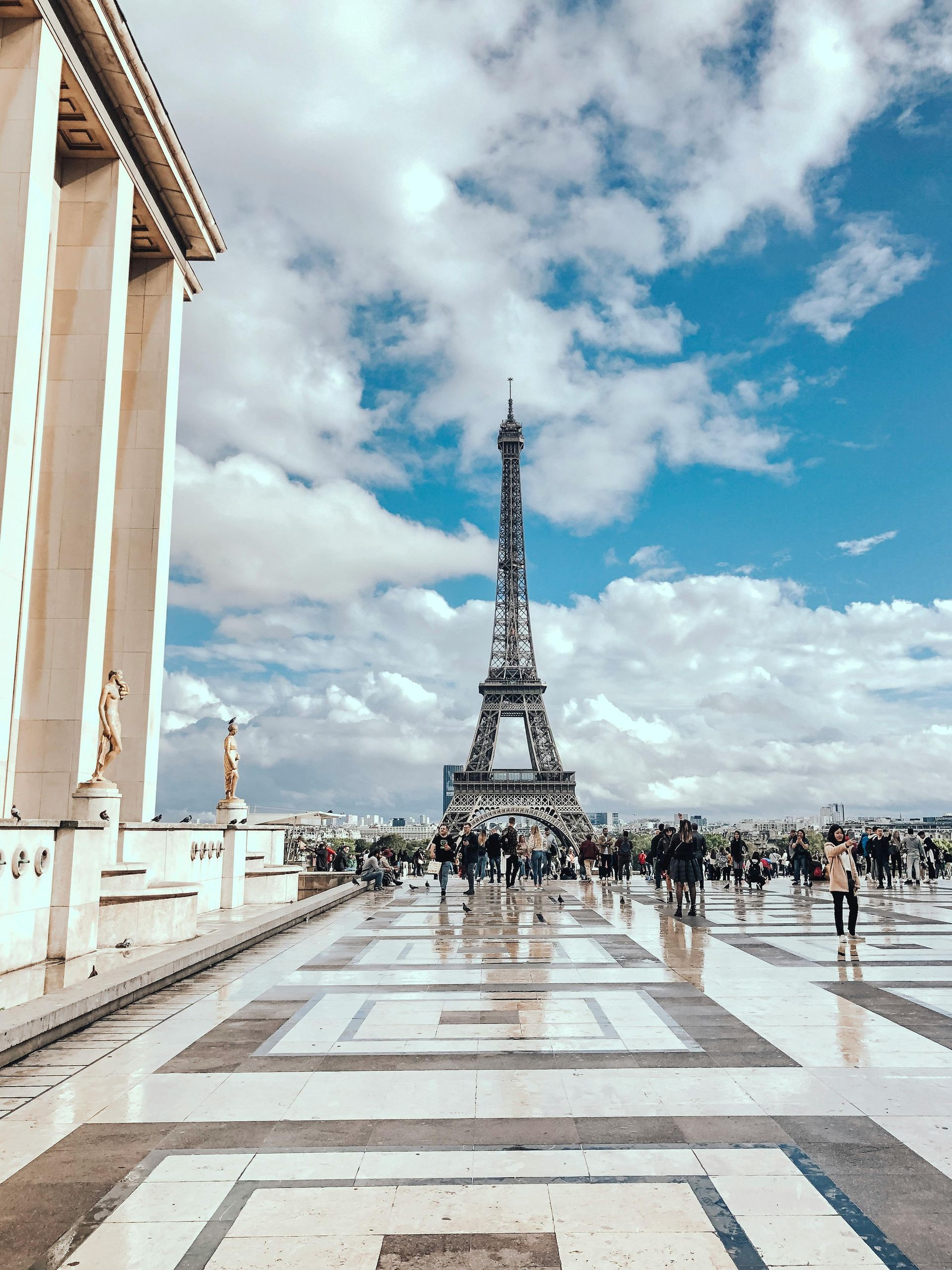 The eiffel tower is surrounded by people and buildings in paris.