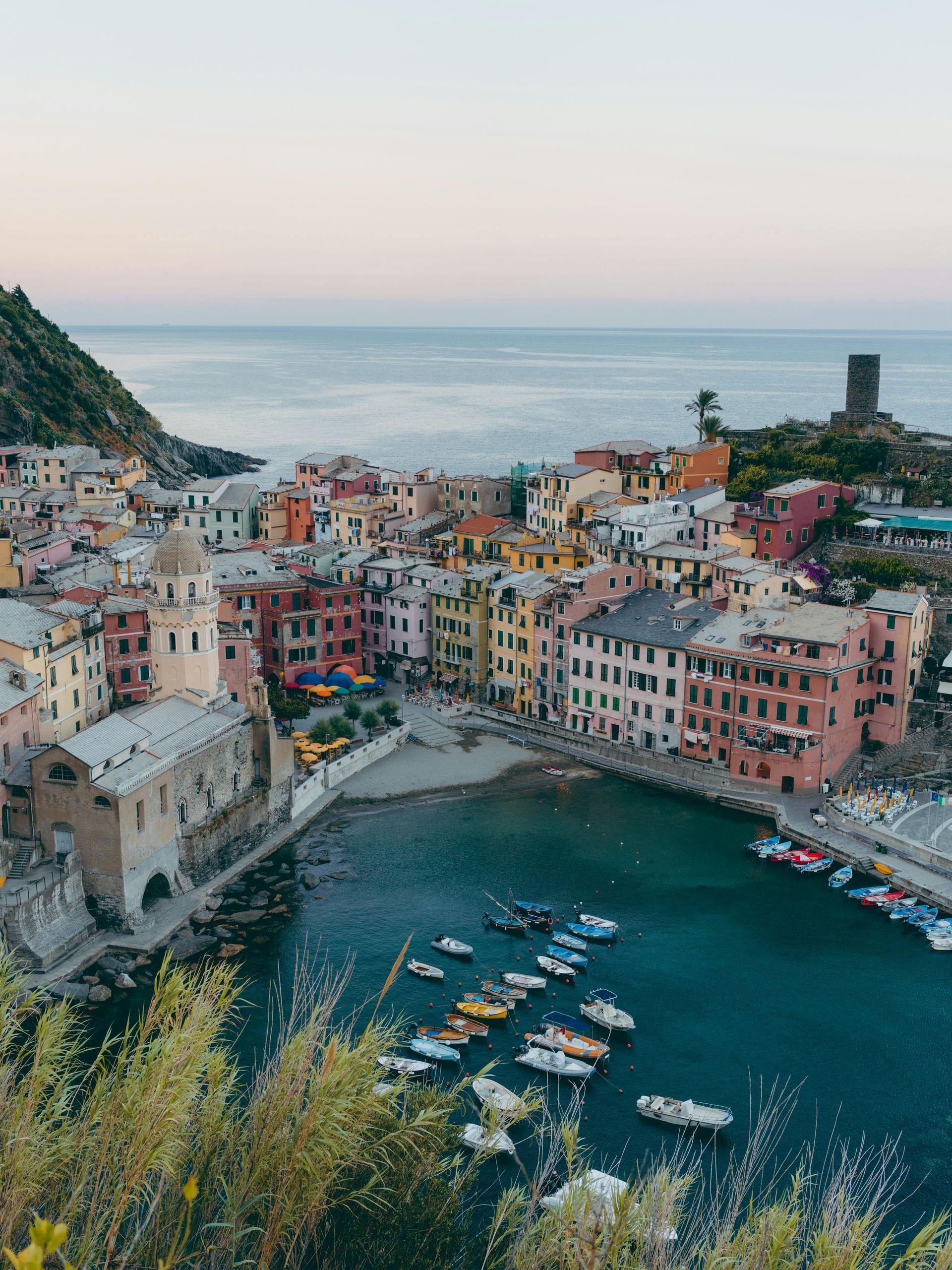 An aerial view of Cinque Terre surrounded by water and boats in Italy.