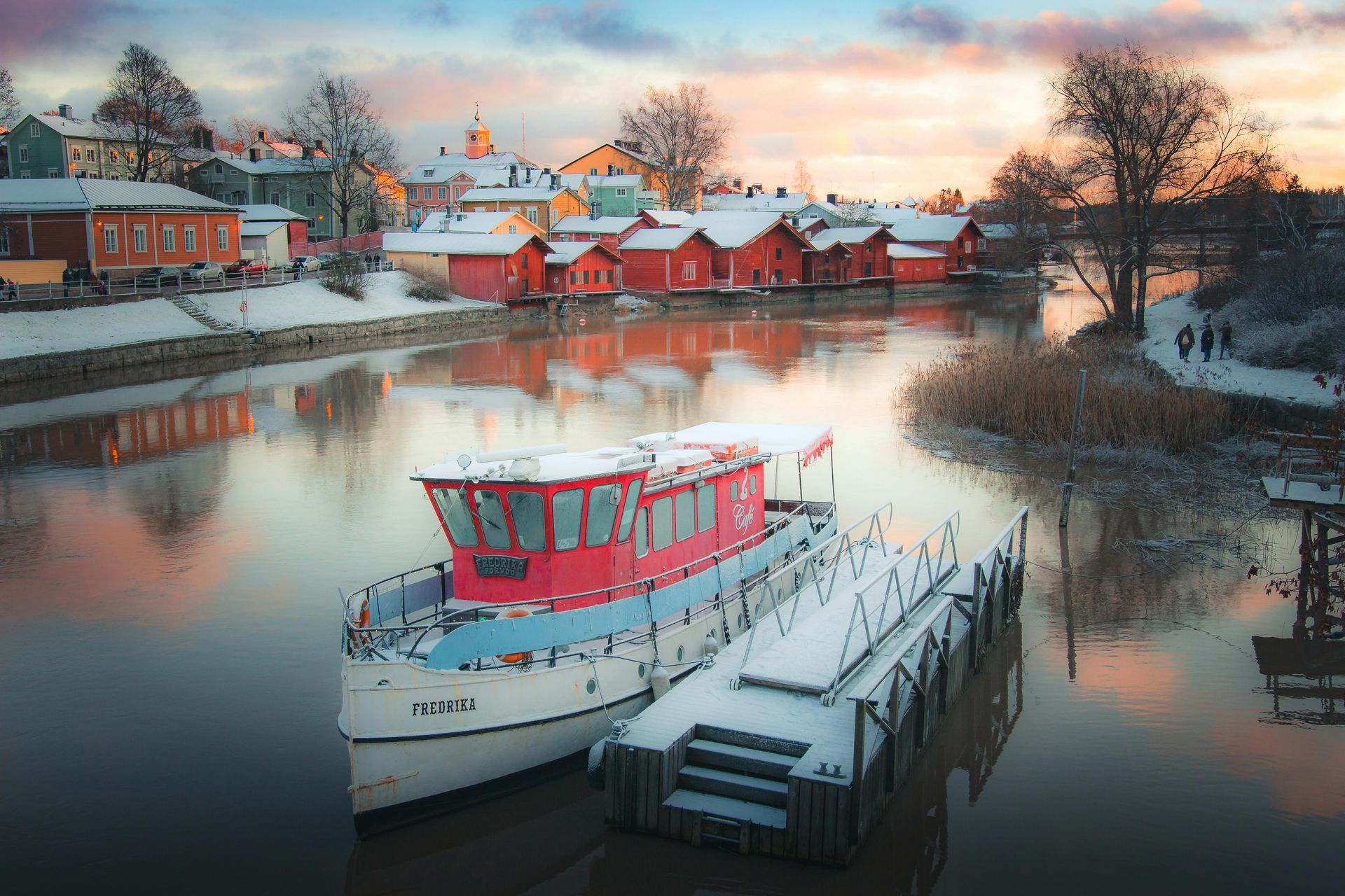 A boat is docked at a dock in the middle of a river in Finland.