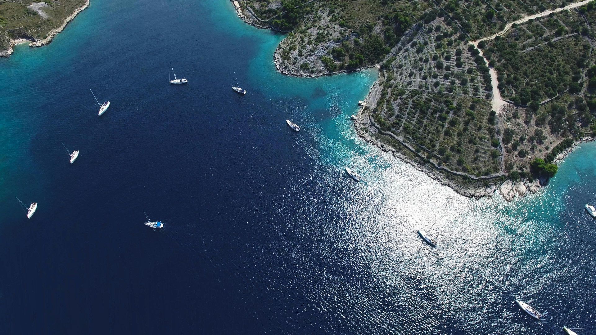 An aerial view of the Mediterranean ocean with boats in it