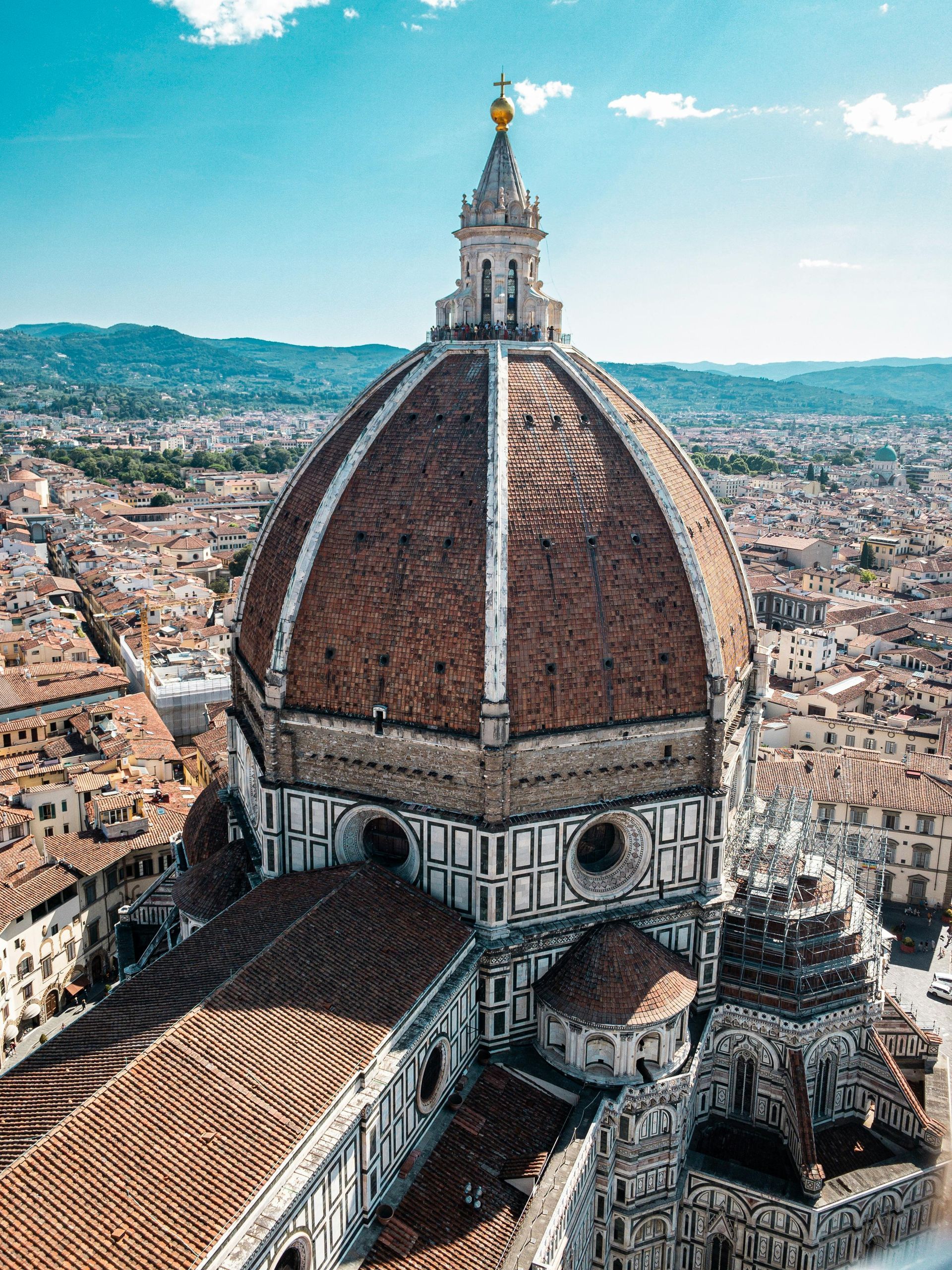 An aerial view of the dome of the florence cathedral with a city in the background.