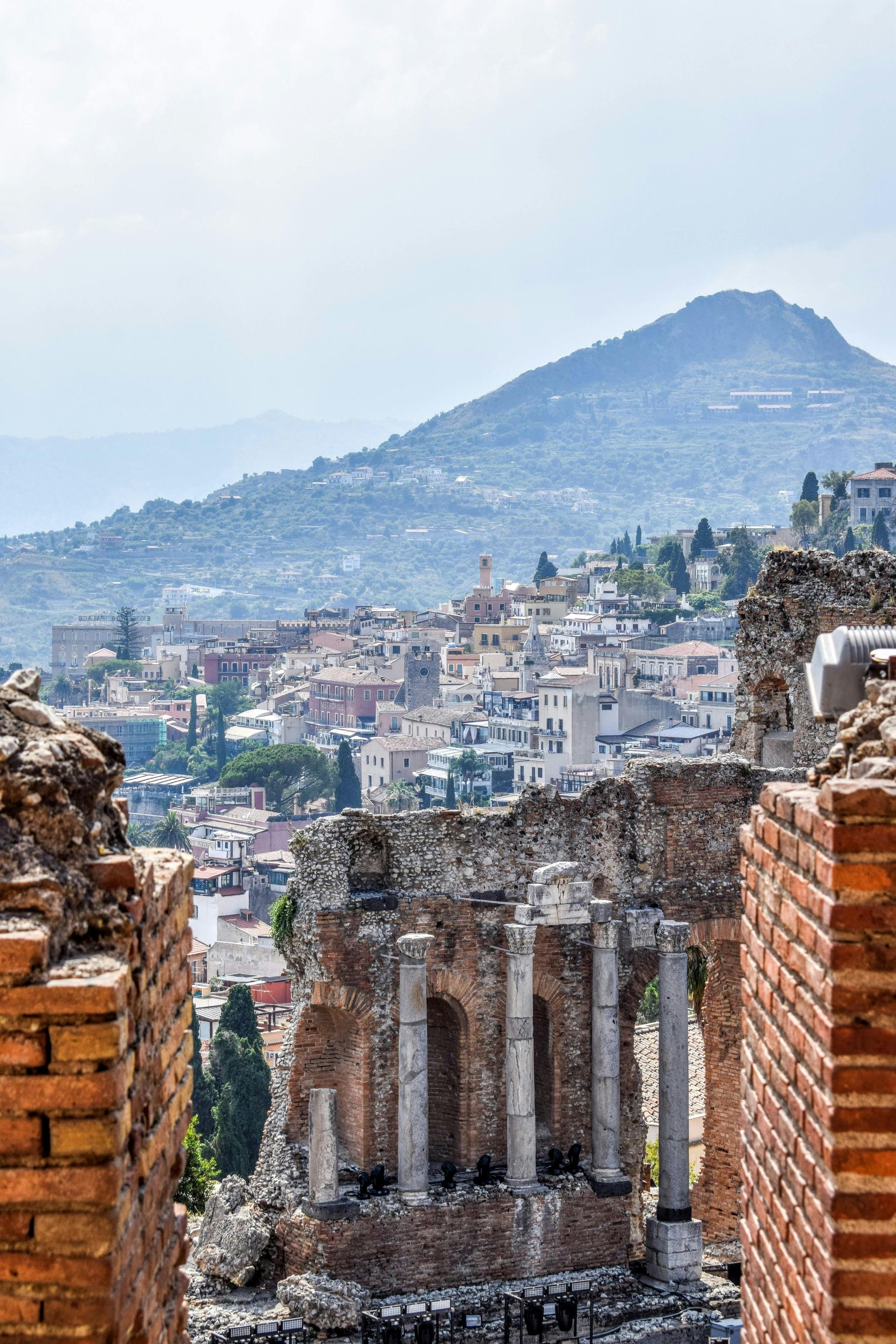 A view of a city from the ruins of an ancient amphitheater in Sicily, Italy.