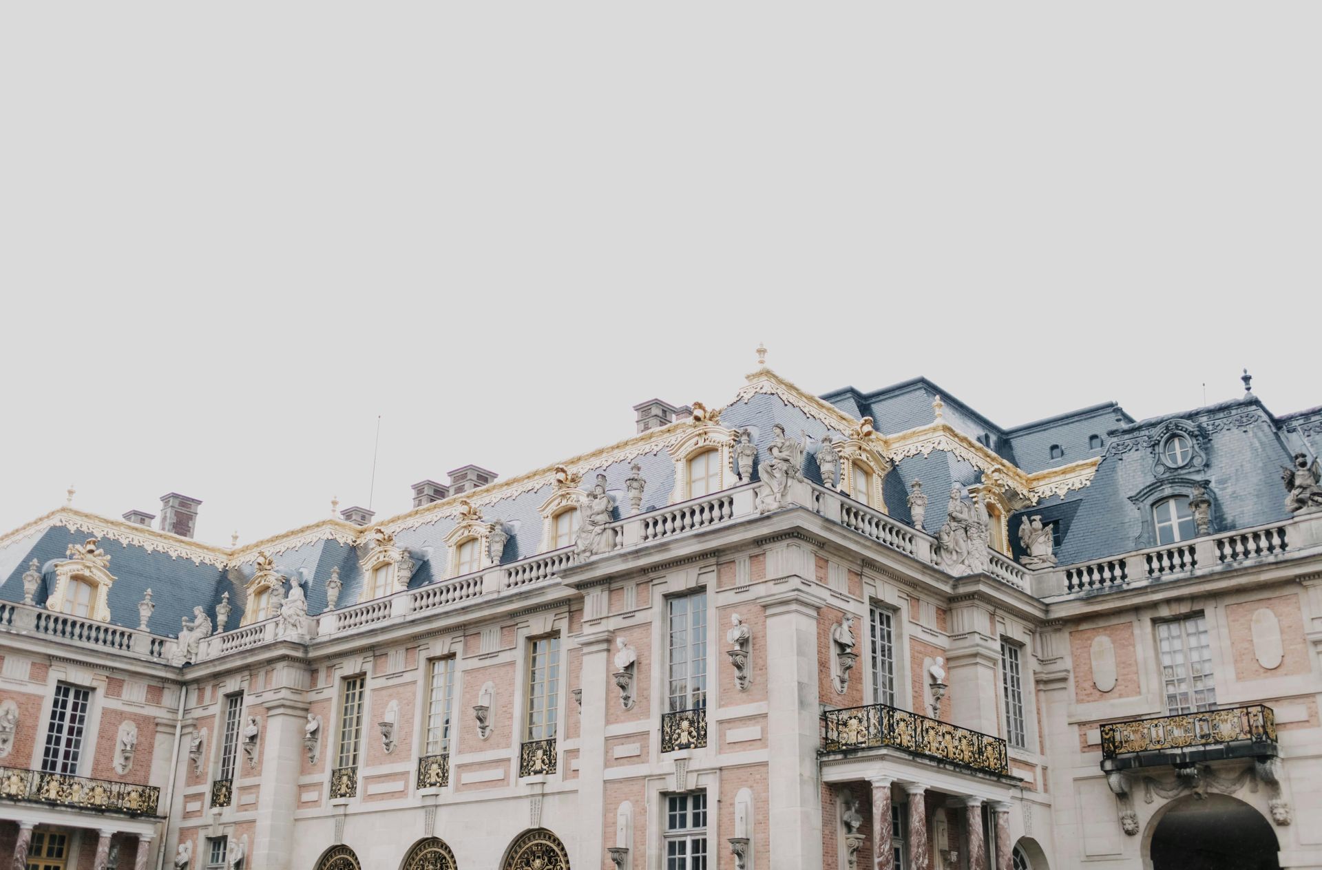 A large building with a lot of windows and balconies on a cloudy day in northern France. 