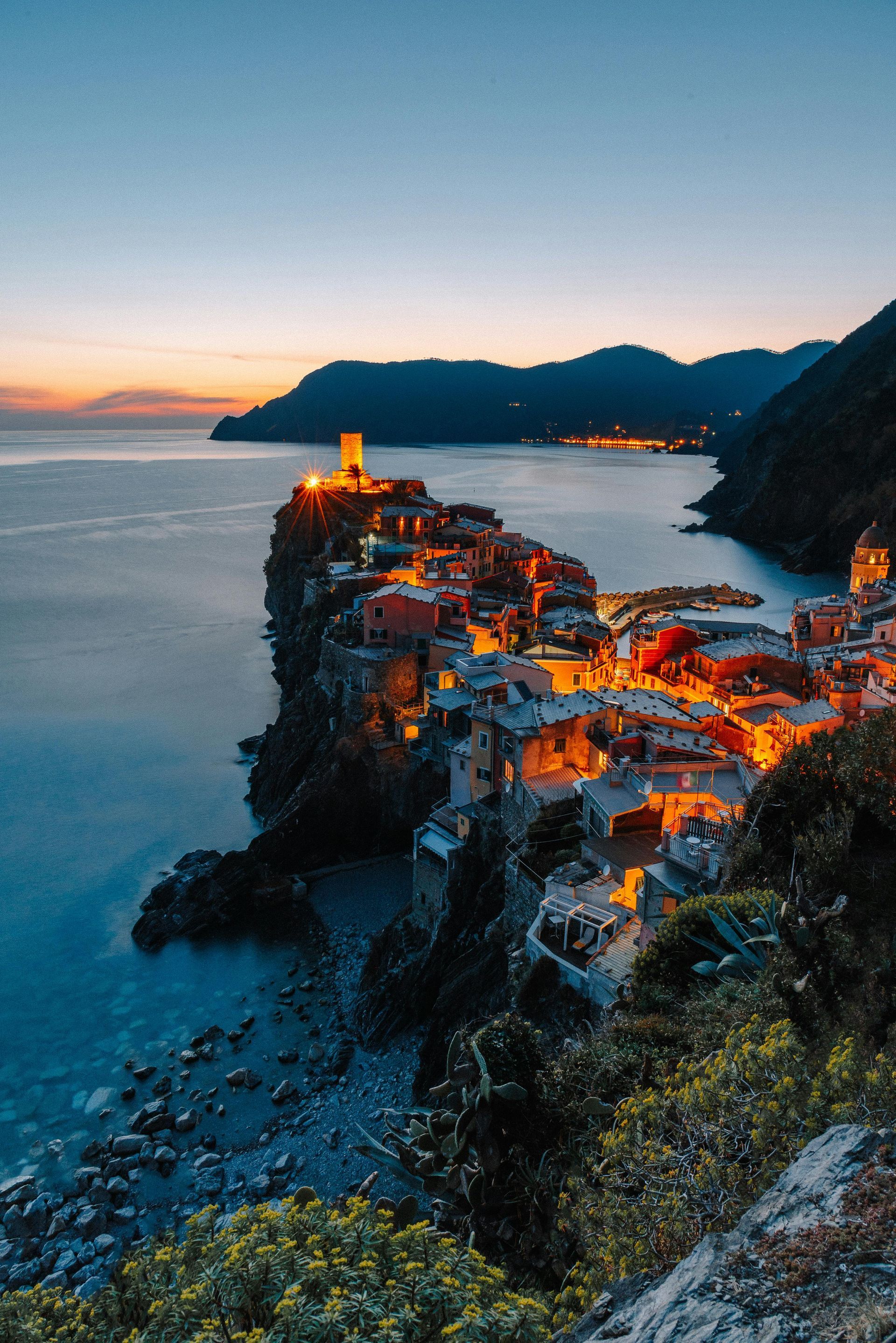 Cinque Terre on a cliff overlooking the ocean at sunset in Italy.