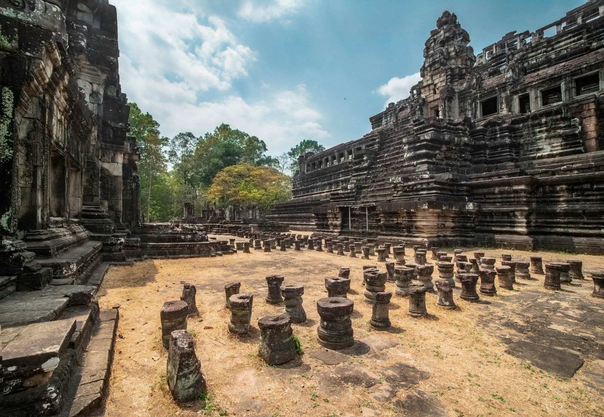 A large stone building with a lot of columns in front of it in Cambodia.