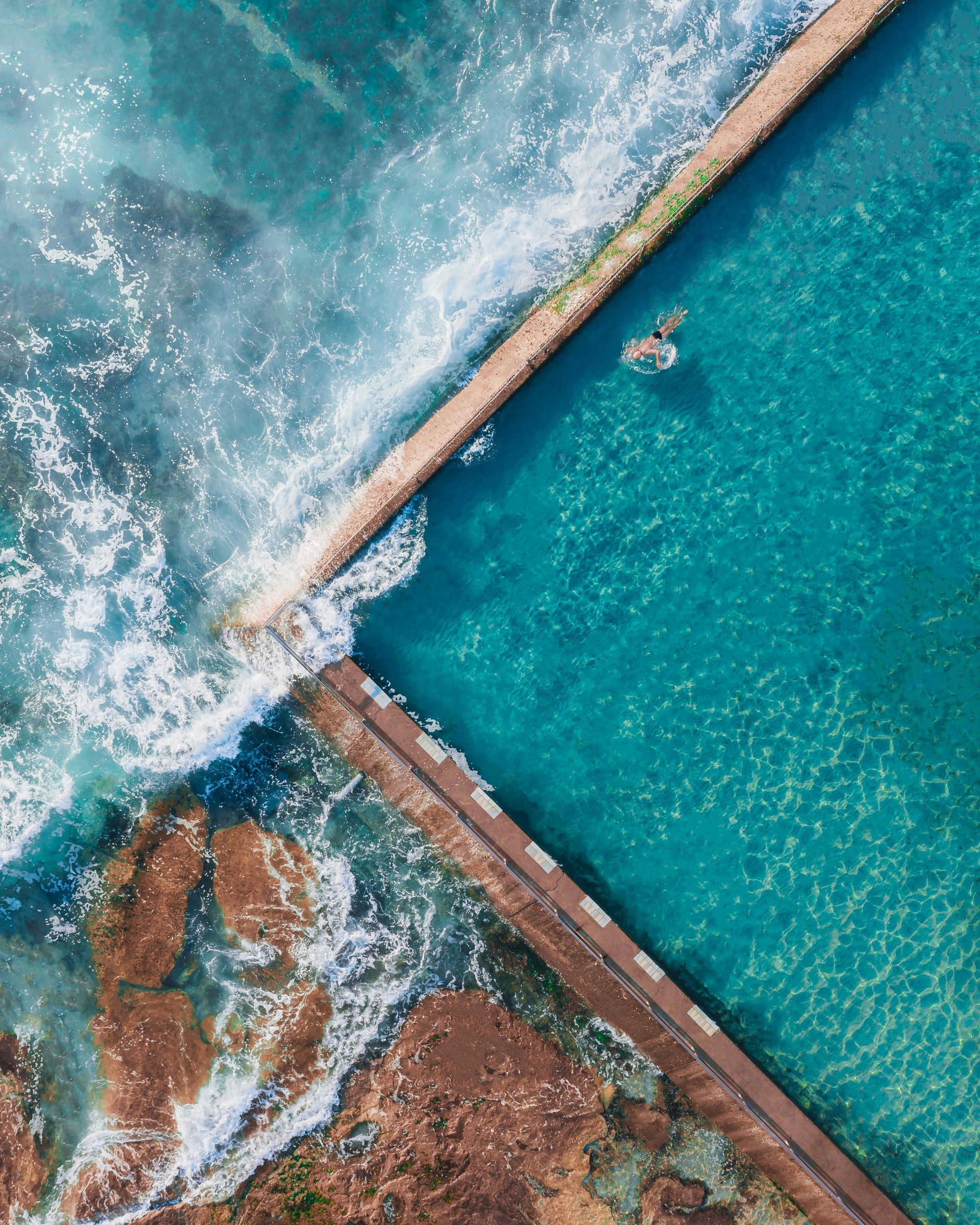 An aerial view of a swimming pool next to the ocean in Australia.