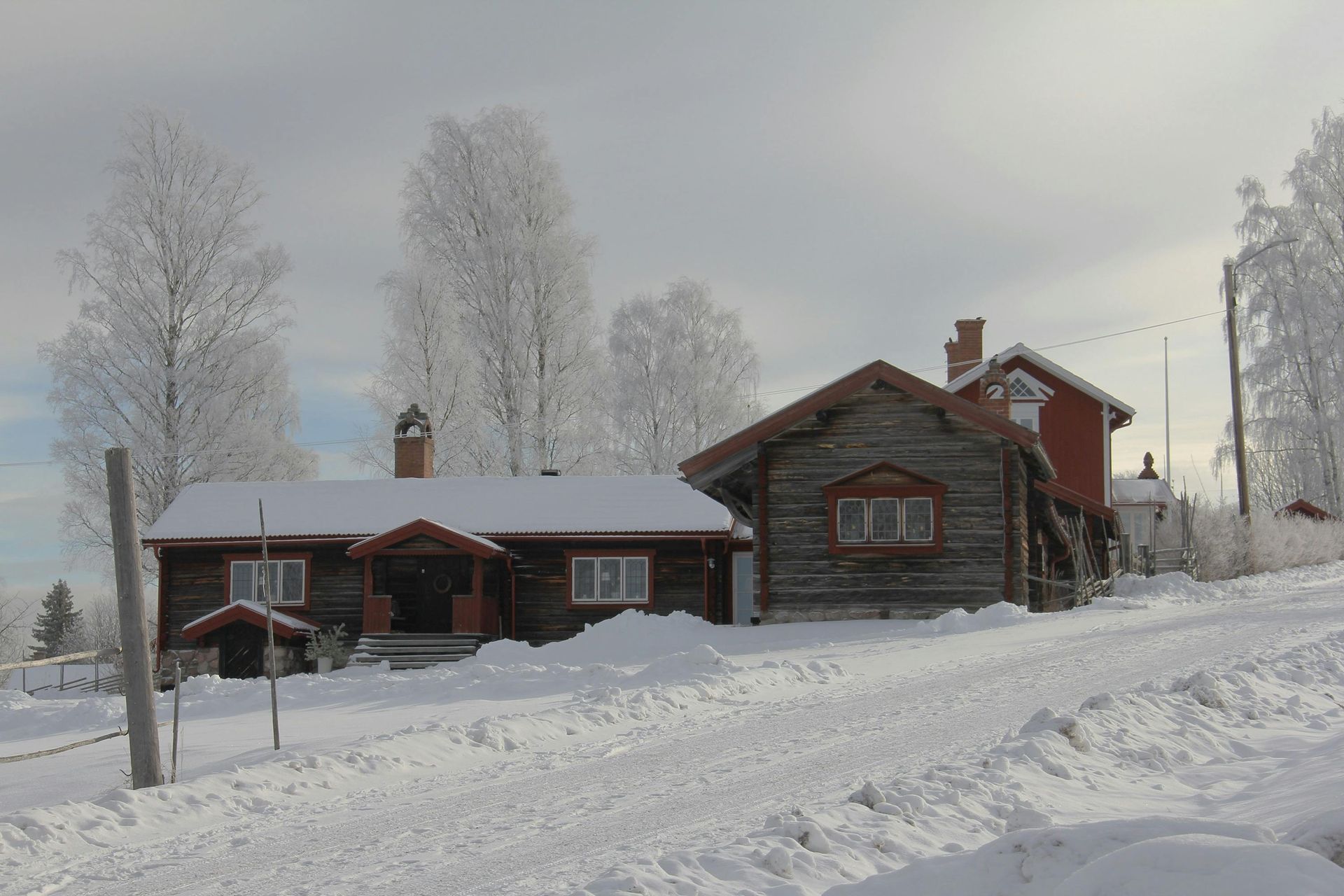 A snowy landscape with a house in the foreground in Sweden.