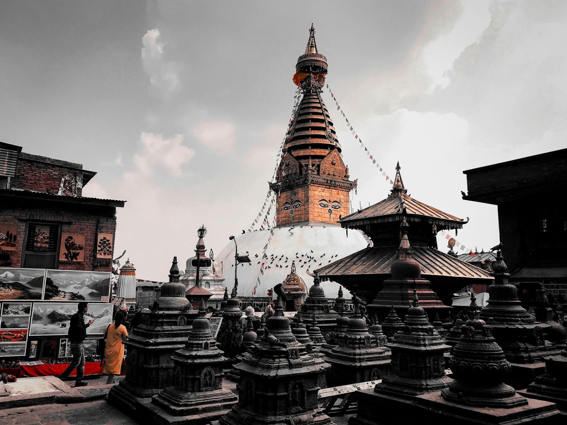 A black and white photo of a temple with a tower in the background in Bhutan.