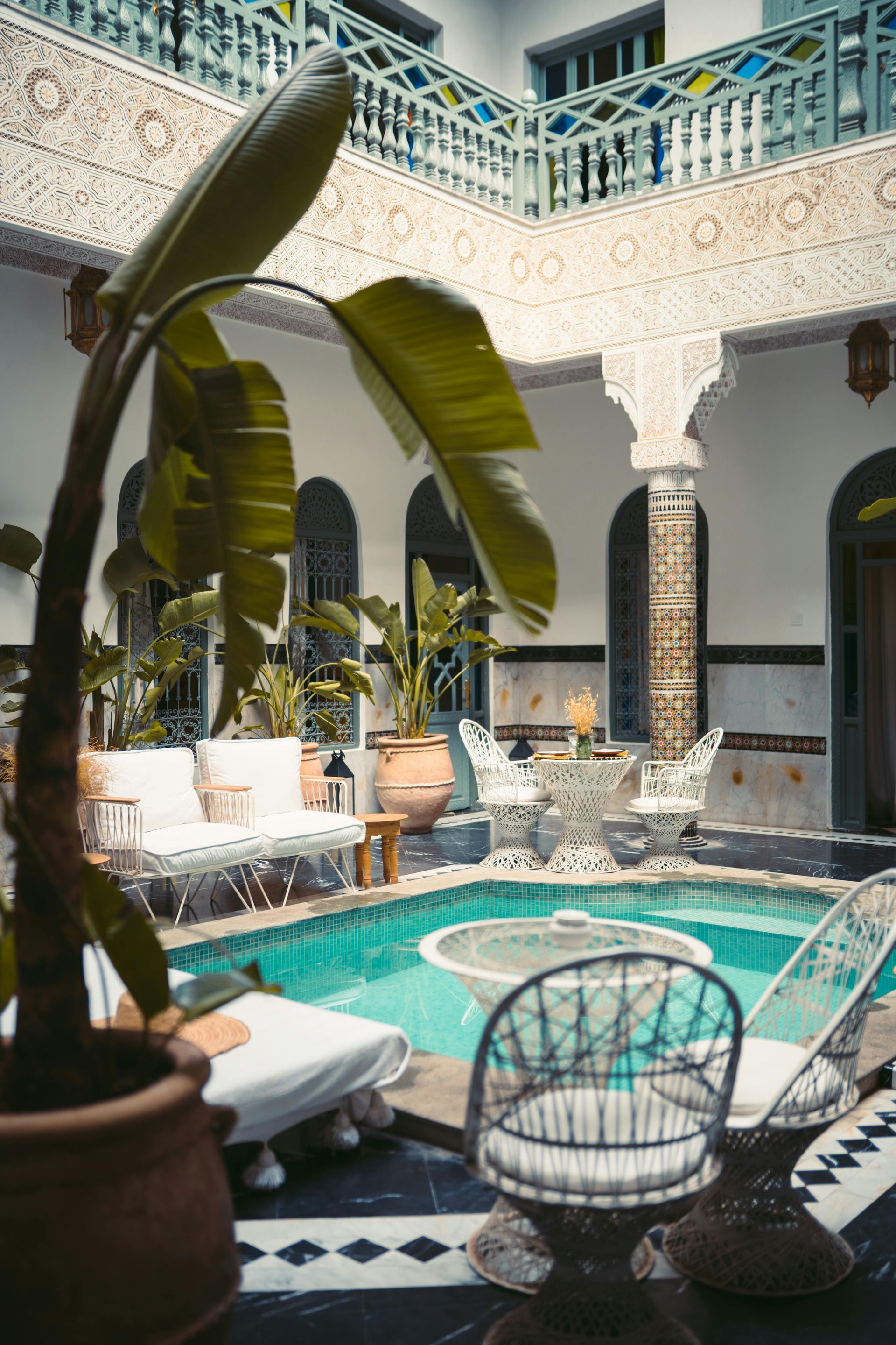 There is a large swimming pool in the middle of a courtyard in Morocco.