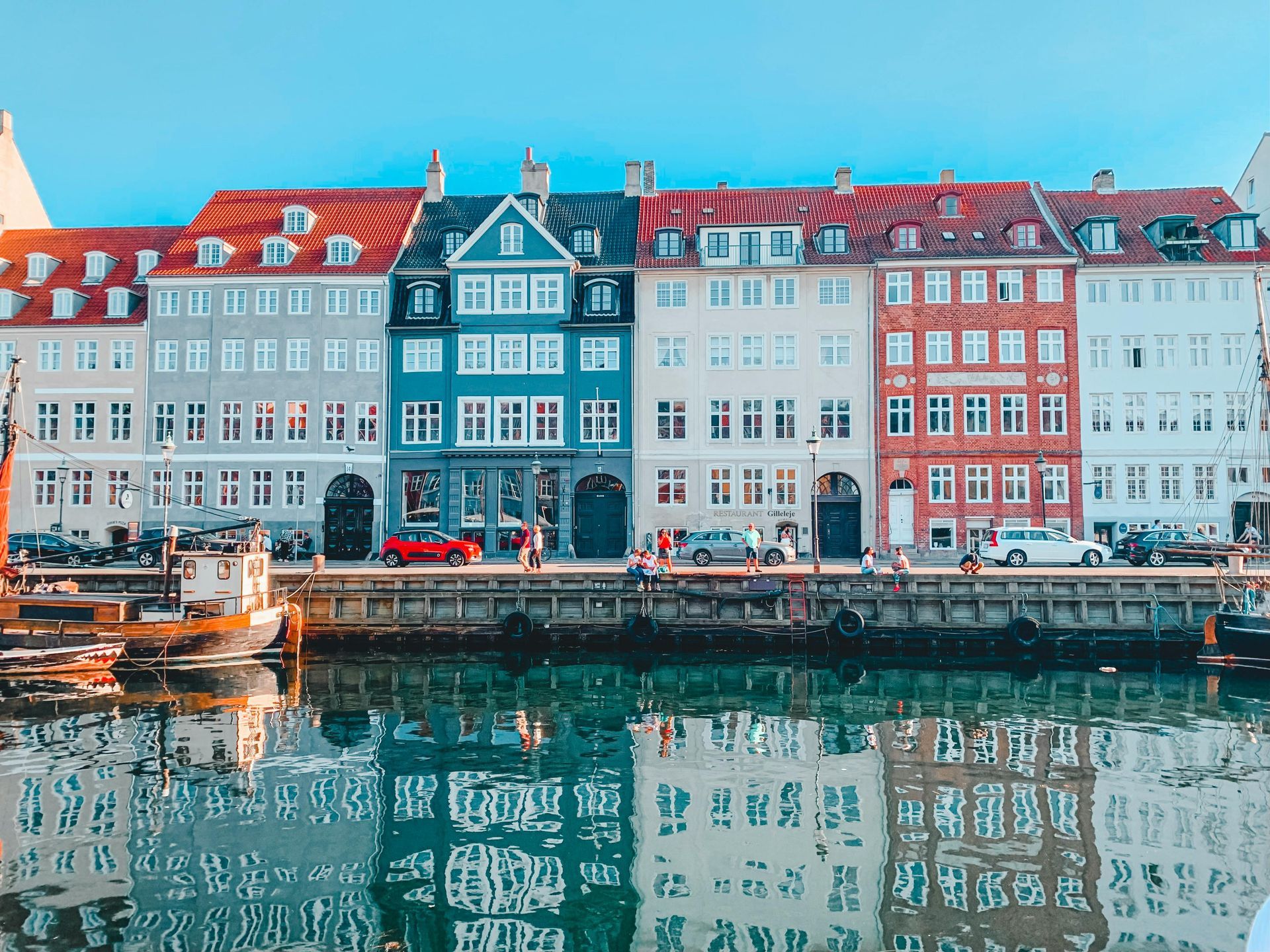 A row of buildings in Copenhagen next to a body of water in Denmark.