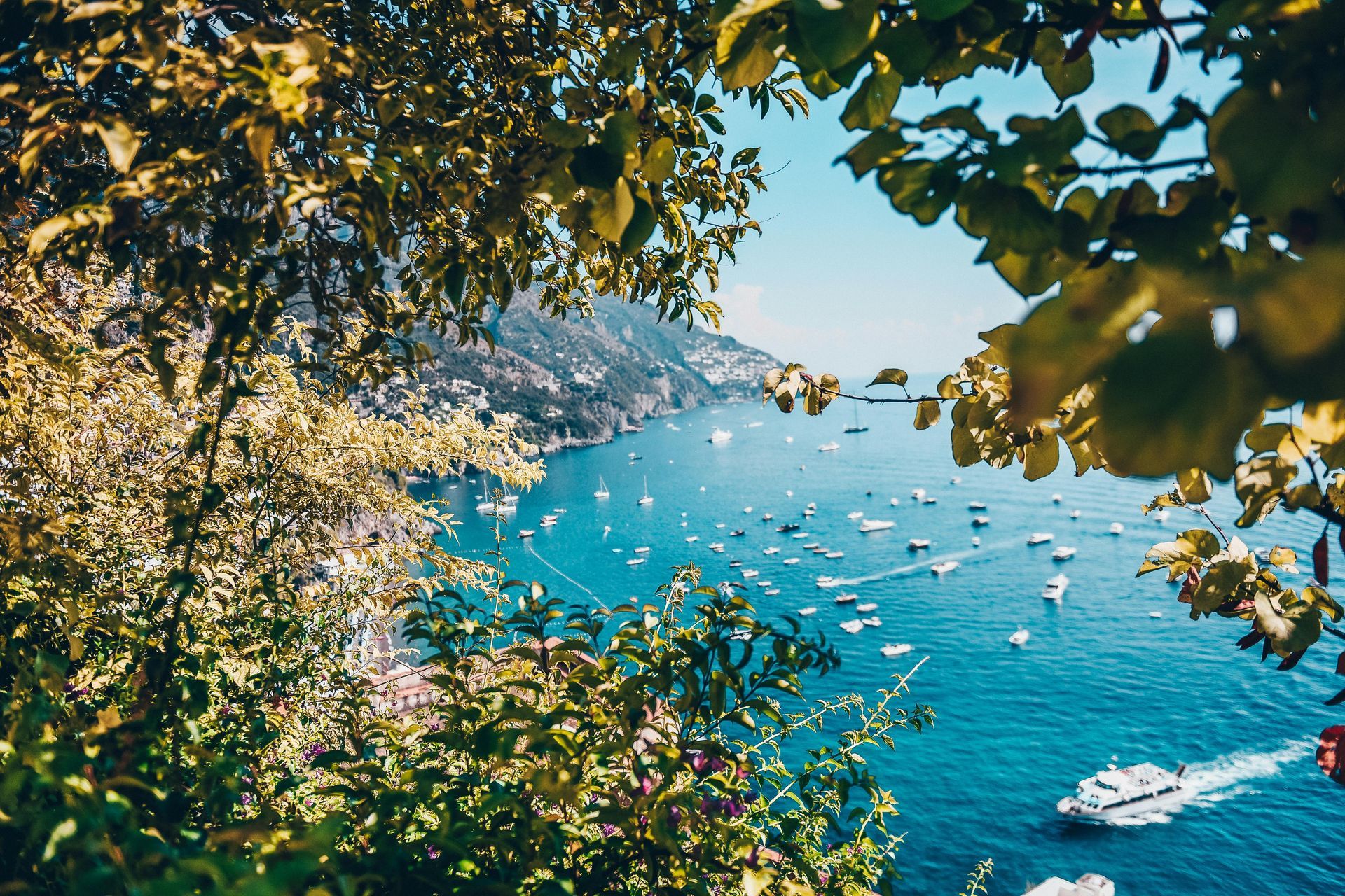 A boat is floating on top of a body of water surrounded by trees in the Amalfi Coast, Italy.